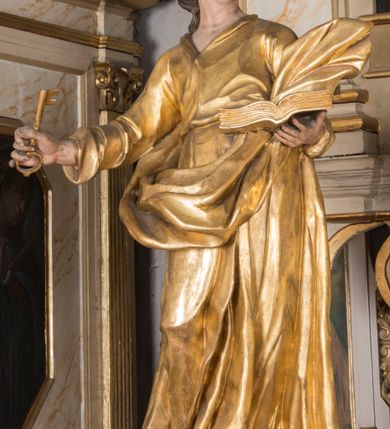 Zdjęcie nr 18: Nastawa architektoniczna, trójosiowa, jednokondygnacyjna ze zwieńczeniem, ustawiona na dwustrefowym cokole, z wyodrębnionymi dwoma prostopadłościanami. Ołtarz prostopadłościenny, z drewnianą mensą. Antepedium ujęte profilowaną ramą z monogramem IHS w polu. 
Osie nastawy wydzielone dwiema parami pilastrów oraz stojącymi przed środkową parą dwiema kolumnami ustawionymi na wydzielonych cokołach. Podpory podtrzymują wyłamujące się ponad nimi belkowanie z mocno wysuniętym gzymsem oraz fragmenty przerwanego przyczółka. Niemal całe pole środkowe wypełnia wnęka w formie stojącego prostokąta zamkniętego łukiem odcinkowym nadwieszonym, ujęta profilowaną ramą, z figurą Chrystusa Ukrzyżowanego. Nad nią rokokowy kartusz z monogramem IHS w polu. Pod nią, w partii predelli, scena z przypowieści o siewcy oraz Umywanie nóg. Na osiach bocznych po dwie arkady w dwóch rzędach ze scenami z życia św. Małgorzaty. Kondygnacja ujęta uszami utworzonymi z rocaille'u. Zwieńczenie w formie kwadratu, flankowane pilastrami przechodzącymi w woluty spływające na belkowanie, zamknięte dwoma odcinkami falowanego gzymsu, zamkniętego szczytem z rocaille'u. W polu, na tle prześwitu oko Opatrzności w otoku z obłoków i uskrzydlonych główek anielskich na tle glorii promienistej. Ołtarz flankowany wysokimi, wolno stojącymi postumentami z figurami św. Piotra i św. Pawła. Struktura polichromowana w odcieniach beżu. W partiach pól antepedium, cokołów, trzonów pilastrów i fryzu retabulum marmoryzacja w odcieniach beżu i brązu; kolumny, profile i ornamentyka złocone, detale srebrzone.  Z tyłu ołtarza tabliczka z napisem: „odnowienie kościoła r(oku) 1882 / z(acnie) w(ielmożnego) x(iędza) proboszcza i. Przybysia / w(ielmożnego) p(ana) Klaeskiego oraz szanownych […] i […] wykonawca tego malowania kościoła Jan Dutkiewicz / wraz czeladzią, Karol Jachimowicz i / Karol Dutkiewicz”.