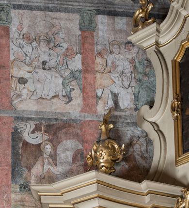 Zdjęcie nr 12: W górnej części ściany północnej nawy dwustrefowy cykl ze scenami z życia i męki Chrystusa. Sceny w iluzjonistycznych obramieniach, w dwóch pasach, utworzonych z szarych cokołów z czerwonymi kolumienkami wydzielającymi kwatery. Górny pas na każdej osi zwieńczony jest szarym, półkolistym tympanonem, dekorowanym ornamentem roślinnym. Sceny w górnym pasie, od lewej: Zwiastowanie, Małżeństwo Marii z Józefem, Pokłon trzech króli, Nauczanie, Wjazd do Jerozolimy, Wypędzenie przekupniów ze świątyni, Ostatnia Wieczerza, Umywanie nóg, Modlitwa w Ogrójcu, Pojmanie i pocałunek Judasza, Jezus u Annasza, Naigrywanie, Jezus przed Piłatem. Sceny w dolnym pasie, od lewej: Zaparcie się św. Piotra, Biczowanie, Judasz oddaje 30 srebrników, Ecce Homo, Umywanie rąk przez Piłata, Droga krzyżowa, Przybicie do krzyża, Ukrzyżowanie, Zdjęcie z krzyża, Złożenie do grobu, Zmartwychwstanie, Noli me tangere (?). Kompozycje scen wielofigurowe, ukazane na tle pejzażu, czasem z widoczną w tle architekturą. Postacie malowane w sposób uproszony i płaszczyznowy, obwiedzione są czarnym konturem, wypełnionym plamą barwną. Po lewej stronie ściany tęczowej przedstawienie Sądu Ostatecznego, częściowo przesłonięte przez ołtarz. W centrum postać tronującego Chrystusa, ukazanego frontalnie, z ugiętą i uniesioną prawą ręką w geście błogosławieństwa, obie stopy opiera na globie. Ubrany jest w czerwony płaszcz, obok jego głowy miecz. Ukazany jest pośród obłoków. Po jego lewej klęczący anioł z rękami złożonymi w geście modlitwy i nadlatujący anioł dmący w trąbę. W prezbiterium wszystkie wysklepki sklepienia pokryte są polichromią, tworzącą z wzoru lilii heraldycznych obramienia, których pola wypełnione są fantazyjną wicią roślinną z kwiatami i ptakami. Wokół otworów okiennych prezbiterium i nawy namalowane są obramienia utworzone z wici roślinnej o regularnie skręconych kwiatach. Otwór tęczowy po wewnętrznej stronie posiada malowidła przedstawiające wić roślinną z dużymi kielichami niebieskich kwiatów. W nawie głównej wzdłuż krawędzi otworu tęczowego namalowano wić roślinną skręconą wokół gałązki. W nawie fryz podstropowy wzdłuż trzech ścian (oprócz północnej), z przedstawieniem wici roślinnej z fantazyjnymi kwiatami i ptakami, o regularnym przebiegu. 

