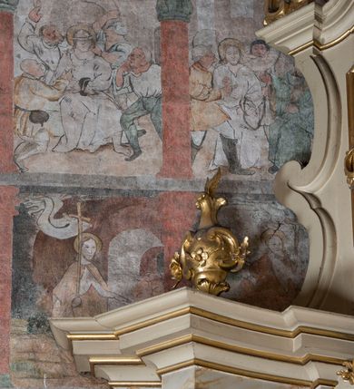Zdjęcie nr 4: W górnej części ściany północnej nawy dwustrefowy cykl ze scenami z życia i męki Chrystusa. Sceny w iluzjonistycznych obramieniach, w dwóch pasach, utworzonych z szarych cokołów z czerwonymi kolumienkami wydzielającymi kwatery. Górny pas na każdej osi zwieńczony jest szarym, półkolistym tympanonem, dekorowanym ornamentem roślinnym. Sceny w górnym pasie, od lewej: Zwiastowanie, Małżeństwo Marii z Józefem, Pokłon trzech króli, Nauczanie, Wjazd do Jerozolimy, Wypędzenie przekupniów ze świątyni, Ostatnia Wieczerza, Umywanie nóg, Modlitwa w Ogrójcu, Pojmanie i pocałunek Judasza, Jezus u Annasza, Naigrywanie, Jezus przed Piłatem. Sceny w dolnym pasie, od lewej: Zaparcie się św. Piotra, Biczowanie, Judasz oddaje 30 srebrników, Ecce Homo, Umywanie rąk przez Piłata, Droga krzyżowa, Przybicie do krzyża, Ukrzyżowanie, Zdjęcie z krzyża, Złożenie do grobu, Zmartwychwstanie, Noli me tangere (?). Kompozycje scen wielofigurowe, ukazane na tle pejzażu, czasem z widoczną w tle architekturą. Postacie malowane w sposób uproszony i płaszczyznowy, obwiedzione są czarnym konturem, wypełnionym plamą barwną. Po lewej stronie ściany tęczowej przedstawienie Sądu Ostatecznego, częściowo przesłonięte przez ołtarz. W centrum postać tronującego Chrystusa, ukazanego frontalnie, z ugiętą i uniesioną prawą ręką w geście błogosławieństwa, obie stopy opiera na globie. Ubrany jest w czerwony płaszcz, obok jego głowy miecz. Ukazany jest pośród obłoków. Po jego lewej klęczący anioł z rękami złożonymi w geście modlitwy i nadlatujący anioł dmący w trąbę. W prezbiterium wszystkie wysklepki sklepienia pokryte są polichromią, tworzącą z wzoru lilii heraldycznych obramienia, których pola wypełnione są fantazyjną wicią roślinną z kwiatami i ptakami. Wokół otworów okiennych prezbiterium i nawy namalowane są obramienia utworzone z wici roślinnej o regularnie skręconych kwiatach. Otwór tęczowy po wewnętrznej stronie posiada malowidła przedstawiające wić roślinną z dużymi kielichami niebieskich kwiatów. W nawie głównej wzdłuż krawędzi otworu tęczowego namalowano wić roślinną skręconą wokół gałązki. W nawie fryz podstropowy wzdłuż trzech ścian (oprócz północnej), z przedstawieniem wici roślinnej z fantazyjnymi kwiatami i ptakami, o regularnym przebiegu. 

