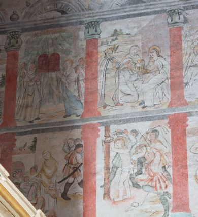 Zdjęcie nr 6: W górnej części ściany północnej nawy dwustrefowy cykl ze scenami z życia i męki Chrystusa. Sceny w iluzjonistycznych obramieniach, w dwóch pasach, utworzonych z szarych cokołów z czerwonymi kolumienkami wydzielającymi kwatery. Górny pas na każdej osi zwieńczony jest szarym, półkolistym tympanonem, dekorowanym ornamentem roślinnym. Sceny w górnym pasie, od lewej: Zwiastowanie, Małżeństwo Marii z Józefem, Pokłon trzech króli, Nauczanie, Wjazd do Jerozolimy, Wypędzenie przekupniów ze świątyni, Ostatnia Wieczerza, Umywanie nóg, Modlitwa w Ogrójcu, Pojmanie i pocałunek Judasza, Jezus u Annasza, Naigrywanie, Jezus przed Piłatem. Sceny w dolnym pasie, od lewej: Zaparcie się św. Piotra, Biczowanie, Judasz oddaje 30 srebrników, Ecce Homo, Umywanie rąk przez Piłata, Droga krzyżowa, Przybicie do krzyża, Ukrzyżowanie, Zdjęcie z krzyża, Złożenie do grobu, Zmartwychwstanie, Noli me tangere (?). Kompozycje scen wielofigurowe, ukazane na tle pejzażu, czasem z widoczną w tle architekturą. Postacie malowane w sposób uproszony i płaszczyznowy, obwiedzione są czarnym konturem, wypełnionym plamą barwną. Po lewej stronie ściany tęczowej przedstawienie Sądu Ostatecznego, częściowo przesłonięte przez ołtarz. W centrum postać tronującego Chrystusa, ukazanego frontalnie, z ugiętą i uniesioną prawą ręką w geście błogosławieństwa, obie stopy opiera na globie. Ubrany jest w czerwony płaszcz, obok jego głowy miecz. Ukazany jest pośród obłoków. Po jego lewej klęczący anioł z rękami złożonymi w geście modlitwy i nadlatujący anioł dmący w trąbę. W prezbiterium wszystkie wysklepki sklepienia pokryte są polichromią, tworzącą z wzoru lilii heraldycznych obramienia, których pola wypełnione są fantazyjną wicią roślinną z kwiatami i ptakami. Wokół otworów okiennych prezbiterium i nawy namalowane są obramienia utworzone z wici roślinnej o regularnie skręconych kwiatach. Otwór tęczowy po wewnętrznej stronie posiada malowidła przedstawiające wić roślinną z dużymi kielichami niebieskich kwiatów. W nawie głównej wzdłuż krawędzi otworu tęczowego namalowano wić roślinną skręconą wokół gałązki. W nawie fryz podstropowy wzdłuż trzech ścian (oprócz północnej), z przedstawieniem wici roślinnej z fantazyjnymi kwiatami i ptakami, o regularnym przebiegu. 

