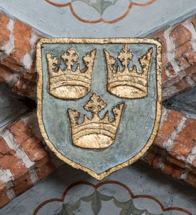 Zdjęcie nr 9: W górnej części ściany północnej nawy dwustrefowy cykl ze scenami z życia i męki Chrystusa. Sceny w iluzjonistycznych obramieniach, w dwóch pasach, utworzonych z szarych cokołów z czerwonymi kolumienkami wydzielającymi kwatery. Górny pas na każdej osi zwieńczony jest szarym, półkolistym tympanonem, dekorowanym ornamentem roślinnym. Sceny w górnym pasie, od lewej: Zwiastowanie, Małżeństwo Marii z Józefem, Pokłon trzech króli, Nauczanie, Wjazd do Jerozolimy, Wypędzenie przekupniów ze świątyni, Ostatnia Wieczerza, Umywanie nóg, Modlitwa w Ogrójcu, Pojmanie i pocałunek Judasza, Jezus u Annasza, Naigrywanie, Jezus przed Piłatem. Sceny w dolnym pasie, od lewej: Zaparcie się św. Piotra, Biczowanie, Judasz oddaje 30 srebrników, Ecce Homo, Umywanie rąk przez Piłata, Droga krzyżowa, Przybicie do krzyża, Ukrzyżowanie, Zdjęcie z krzyża, Złożenie do grobu, Zmartwychwstanie, Noli me tangere (?). Kompozycje scen wielofigurowe, ukazane na tle pejzażu, czasem z widoczną w tle architekturą. Postacie malowane w sposób uproszony i płaszczyznowy, obwiedzione są czarnym konturem, wypełnionym plamą barwną. Po lewej stronie ściany tęczowej przedstawienie Sądu Ostatecznego, częściowo przesłonięte przez ołtarz. W centrum postać tronującego Chrystusa, ukazanego frontalnie, z ugiętą i uniesioną prawą ręką w geście błogosławieństwa, obie stopy opiera na globie. Ubrany jest w czerwony płaszcz, obok jego głowy miecz. Ukazany jest pośród obłoków. Po jego lewej klęczący anioł z rękami złożonymi w geście modlitwy i nadlatujący anioł dmący w trąbę. W prezbiterium wszystkie wysklepki sklepienia pokryte są polichromią, tworzącą z wzoru lilii heraldycznych obramienia, których pola wypełnione są fantazyjną wicią roślinną z kwiatami i ptakami. Wokół otworów okiennych prezbiterium i nawy namalowane są obramienia utworzone z wici roślinnej o regularnie skręconych kwiatach. Otwór tęczowy po wewnętrznej stronie posiada malowidła przedstawiające wić roślinną z dużymi kielichami niebieskich kwiatów. W nawie głównej wzdłuż krawędzi otworu tęczowego namalowano wić roślinną skręconą wokół gałązki. W nawie fryz podstropowy wzdłuż trzech ścian (oprócz północnej), z przedstawieniem wici roślinnej z fantazyjnymi kwiatami i ptakami, o regularnym przebiegu. 

