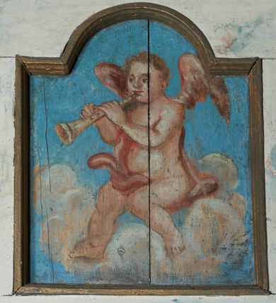 Zdjęcie nr 6: Balustrada chóru muzycznego dziewięcioosiowa, jednokondygnacyjna, od spodu z podwieszonym lambrekinem, na osi środkowej wypukła. Osie flankowane kolumienkami ustawionymi na cokołach, które podtrzymują imposty ustawione pod kątem, wyłamujące profilowany gzyms balustrady. Trzony kolumienek malowane na czarno, kapitele stylizowane na korynckie, złocone. W każdej osi umieszczona płycina w kształcie stojącego prostokąta zamknięta łukiem nadwieszonym. Kolejno od lewej strony malowane w płycinach obrazy: aniołek grający na trąbce, aniołek grający na bębnach, ponownie aniołek grający na trąbce i aniołek grający na skrzypach. Na środku osi płycina w kształcie stojącego prostokąta zamknięta trójkątnie o wyłamanym zwieńczeniu, w polu przedstawienie króla Dawida grającego na harfie. U góry banderola z napisem „LAUDATE DOMINUM IN CITHARA”. Po drugiej stronie balustrady, kolejno od lewej: aniołek grający na wiolonczeli, aniołek grający na trąbce, aniołek grający na flecie i aniołek grający na mandolinie. Wszystkie postacie ukazane na jasnobłękitnym tle, na chmurze białych obłoków. Anioły półnagie, ubrane w czerwone szaty. Struktura balustrady marmoryzowana na biało z niebieskimi przetarciami, detale złocone i malowane na czarno.
