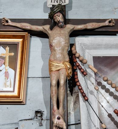 Zdjęcie nr 2: Krzyż prosty, współczesny. Rzeźba zawieszona na krzyżu na wyprostowanych ramionach, figura w typie Christo vivo, głowa delikatnie przechylona na prawe ramię; nogi ugięte w kolanach, stopy przebite jednym gwoździem w układzie prawa na lewą. Twarz Chrystusa pociągła, o wyraźnych rysach, dużym i wąskim nosie; okolona krótkim zarostem; na głowie szeroka korona cierniowa. Sylwetka wychudzona, z wydatną klatką piersiową i wąską talią. Perizonium przewiązane na lewym boku, ciasno oplatające biodra. Nad głowią Chrystusa znajduje się titulus w formie białej banderoli z napisem „INRI”. Polichromia naturalistyczna w odsłoniętych partiach ciała z zaznaczonymi śladami męki, perizonium złocone.