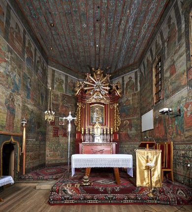 Zdjęcie nr 75: Polichromia ścienna prezbiterium
Polichromia w tej części świątyni podzielona jest na cztery strefy. W pierwszej znajduje się dekoracja ornamentalna, kolejne dwie strefy ukazują sceny z życia Marii i Jezusa, ostatnia strefa ukazuje rząd portretów męskich w strojach z epoki.  W dolnej strefie prezbiterium są umieszczone również trzy krzyże konsekracyjne, wpisane w okrągłe wieńce. Na północnej ścianie prezbiterium w scenach z cyklu maryjnego, od lewej znajdują się: Św. Anna Samotrzeć, Pokłon Trzech Króli, Chrystus Baranek Boży opatrzony banderolą z napisem: „EGO SVM PASTOR BONVS”, Ucieczka do Egiptu, scena Ukrzyżowania z postaciami fundatorów. W drugiej strefie na ścianie północnej od lewej ukazano: św. Annę z małą Marią; Ofiarowanie w świątyni z fragmentami napisu u spodu: „RV (?) NOBIS (?) NOBIS”; Zwiastowanie z napisem: „ECCE VIRGO CONCIPIET ET PARIET FILIUM EI VO”, Nawiedzenie Najświętszej Marii Panny, u spodu napis: „VIRGO MARIA (?) NAV(?) (?)AB(?)” oraz Wniebowzięcie Najświętszej Marii Panny z fragmentarycznie zachowanym napisem: „(?)VAE EST ASC(?)”. W ostatniej strefie na ścianie północnej ukazano rząd męskich portretów. Na południowej ścianie prezbiterium w dolnej strefie znajduje się dekoracja ornamentalna. Następnie w strefie drugiej od lewej strony ukazane są kolejno sceny: Najświętsza Maria Panna Niepokalanie Poczęta, Tron Łaski, Trzy Marie u grobu, Nauczanie Chrystusa, a w strefie trzeciej, również od lewej strony: Przemienienie na górze Tabor z fragmentarycznie zachowanym napisem: „(?) BV(?)O (…) RA(?) (?)AT”, następnie Modlitwa w Ogrójcu(?), Zmartwychwstanie Chrystusa. W trzeciej strefie kontynuacja porterów męskich, w tym władców w koronach na głowie i z berłami w dłoniach. Na wschodniej ścianie prezbiterium, przy ołtarzu głównym przedstawiono Ewangelistów: po stronie lewej św. Mateusza, a po prawej św. Marka. W dolnej strefie po lewej: św. Łukasz, a po prawej św. Jan.

Polichromia ścienna nawy
Polichromię wypełniają przedstawienia Męki Pańskiej: Zdjęcie z krzyża, Opłakiwanie Chrystusa, Złożenie do Grobu  oraz postacie Apostołów namalowane na zaskrzynieniach. Kilka scen zasłania ołtarz Ukrzyżowania. Na południowej ścianie nawy zachowało się tylko gigantyczne przedstawienie św. Krzysztofa na wysokość całej nawy. Ponadto w nawie znajdują się sceny, częściowo przesłonięte przez prospekt organowy i ołtarze: Wyszydzanie Chrystusa, Chrystus bity pięścią po głowie przez oprawcę, Dźwigane krzyża, Zesłanie Ducha Świętego, Przybicie do krzyża, Chrzest w Jordanie, Ostatnia Wieczerza, Modlitwa w Ogrójcu, Pojmanie.

Ściana łuku arkady tęczowej
Na ścianie tej znajduje się scena Sądu Ostatecznego. U szczytu zasiada Chrystus – Sędzia, odziany w czerwony płaszcz i unoszący rękę ku górze. Po jego bokach ukazano: Matkę Boską, św. Jana Chrzciciela, proroków, apostołów, symbole ewangelistów, a także potępione dusze. 

Stropy prezbiterium i korpusu nawowego, a także zaskrzynień (z wyjątkiem strony północnej, gdzie są ukazani Apostołowie), cokół w prezbiterium i korpusie pokrywa pasowa dekoracja ornamentalna umieszczona na czarnym tle. Ozdabia również obramowania okienne, a w prezbiterium tworzy fryz łączący ściany. 
 