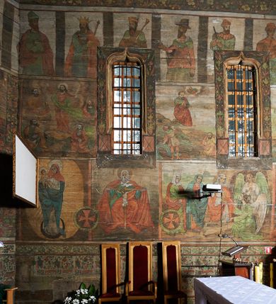 Zdjęcie nr 27: Polichromia ścienna prezbiterium
Polichromia w tej części świątyni podzielona jest na cztery strefy. W pierwszej znajduje się dekoracja ornamentalna, kolejne dwie strefy ukazują sceny z życia Marii i Jezusa, ostatnia strefa ukazuje rząd portretów męskich w strojach z epoki.  W dolnej strefie prezbiterium są umieszczone również trzy krzyże konsekracyjne, wpisane w okrągłe wieńce. Na północnej ścianie prezbiterium w scenach z cyklu maryjnego, od lewej znajdują się: Św. Anna Samotrzeć, Pokłon Trzech Króli, Chrystus Baranek Boży opatrzony banderolą z napisem: „EGO SVM PASTOR BONVS”, Ucieczka do Egiptu, scena Ukrzyżowania z postaciami fundatorów. W drugiej strefie na ścianie północnej od lewej ukazano: św. Annę z małą Marią; Ofiarowanie w świątyni z fragmentami napisu u spodu: „RV (?) NOBIS (?) NOBIS”; Zwiastowanie z napisem: „ECCE VIRGO CONCIPIET ET PARIET FILIUM EI VO”, Nawiedzenie Najświętszej Marii Panny, u spodu napis: „VIRGO MARIA (?) NAV(?) (?)AB(?)” oraz Wniebowzięcie Najświętszej Marii Panny z fragmentarycznie zachowanym napisem: „(?)VAE EST ASC(?)”. W ostatniej strefie na ścianie północnej ukazano rząd męskich portretów. Na południowej ścianie prezbiterium w dolnej strefie znajduje się dekoracja ornamentalna. Następnie w strefie drugiej od lewej strony ukazane są kolejno sceny: Najświętsza Maria Panna Niepokalanie Poczęta, Tron Łaski, Trzy Marie u grobu, Nauczanie Chrystusa, a w strefie trzeciej, również od lewej strony: Przemienienie na górze Tabor z fragmentarycznie zachowanym napisem: „(?) BV(?)O (…) RA(?) (?)AT”, następnie Modlitwa w Ogrójcu(?), Zmartwychwstanie Chrystusa. W trzeciej strefie kontynuacja porterów męskich, w tym władców w koronach na głowie i z berłami w dłoniach. Na wschodniej ścianie prezbiterium, przy ołtarzu głównym przedstawiono Ewangelistów: po stronie lewej św. Mateusza, a po prawej św. Marka. W dolnej strefie po lewej: św. Łukasz, a po prawej św. Jan.

Polichromia ścienna nawy
Polichromię wypełniają przedstawienia Męki Pańskiej: Zdjęcie z krzyża, Opłakiwanie Chrystusa, Złożenie do Grobu  oraz postacie Apostołów namalowane na zaskrzynieniach. Kilka scen zasłania ołtarz Ukrzyżowania. Na południowej ścianie nawy zachowało się tylko gigantyczne przedstawienie św. Krzysztofa na wysokość całej nawy. Ponadto w nawie znajdują się sceny, częściowo przesłonięte przez prospekt organowy i ołtarze: Wyszydzanie Chrystusa, Chrystus bity pięścią po głowie przez oprawcę, Dźwigane krzyża, Zesłanie Ducha Świętego, Przybicie do krzyża, Chrzest w Jordanie, Ostatnia Wieczerza, Modlitwa w Ogrójcu, Pojmanie.

Ściana łuku arkady tęczowej
Na ścianie tej znajduje się scena Sądu Ostatecznego. U szczytu zasiada Chrystus – Sędzia, odziany w czerwony płaszcz i unoszący rękę ku górze. Po jego bokach ukazano: Matkę Boską, św. Jana Chrzciciela, proroków, apostołów, symbole ewangelistów, a także potępione dusze. 

Stropy prezbiterium i korpusu nawowego, a także zaskrzynień (z wyjątkiem strony północnej, gdzie są ukazani Apostołowie), cokół w prezbiterium i korpusie pokrywa pasowa dekoracja ornamentalna umieszczona na czarnym tle. Ozdabia również obramowania okienne, a w prezbiterium tworzy fryz łączący ściany. 
 