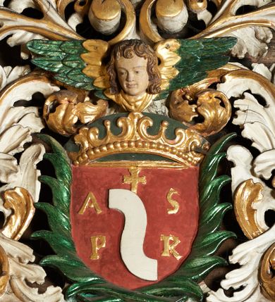 Zdjęcie nr 7: Ołtarz jednokondygnacyjny, jednoosiowy ze zwieńczeniem, ustawiony na mensie. Mensa drewniana, prostopadłościenna, z przodu malowana na czerwono płycina z krzyżem oraz dwiema skrzyżowanymi gałązkami palm w polu. Cokół nastawy flankowany przez dwie rzeźby aniołów; pośrodku obraz „Ścięcie św. Jana Chrzciciela” w owalu. Kondygnacja złożona z obrazu z przedstawieniem św. Andrzeja w kształcie stojącego prostokąta otoczonego przez bujne wici liści akantu. Nad obrazem herb Szreniawa z syglami w polu tarczy A(NDRZEJ) S(TRZAŁKOWSKI) P(ROBOSZCZ) R(ACŁAWICKI). Tarcza zwieńczona otwartą koroną, nad którą umieszczono skrzydlatą główkę aniołka skierowaną na wprost. W zwieńczeniu ołtarza owalny obraz „Święty Antoni Padewski” w ramie z bujnego akantu. U szczytu oraz po bokach zwieńczenia trzy rzeźby aniołów. Struktura polichromowana w kolorze jasnego beżu; detale, ornamentyka i profilowania złocone.
