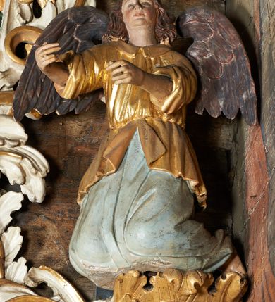 Zdjęcie nr 8: Ołtarz jednokondygnacyjny, jednoosiowy ze zwieńczeniem, ustawiony na mensie. Mensa drewniana, prostopadłościenna, z przodu malowana na czerwono płycina z gorejącym sercem oraz dwiema skrzyżowanymi gałązkami palm w polu. Cokół nastawy flankowany przez dwie rzeźby aniołów; pośrodku obraz „Zaśnięcie Najświętszej Marii Panny” w owalu. Kondygnacja złożona z obrazu z przedstawieniem św. Piotra w kształcie stojącego prostokąta, otoczonego przez bujne wici liści akantu. Nad obrazem herb Szreniawa z syglami w polu tarczy A(NDRZEJ) S(TRZAŁKOWSKI) P(ROBOSZCZ) R(ACŁAWICKI). Tarcza zwieńczona otwartą koroną, nad którą umieszczono skrzydlatą główkę aniołka skierowaną na wprost. W zwieńczeniu ołtarza owalny obraz „Święty Paweł” w ramie z bujnego akantu. U szczytu oraz po bokach zwieńczenia trzy rzeźby aniołów. Struktura polichromowana w kolorze jasnego beżu; detale, ornamentyka i profilowania złocone.
