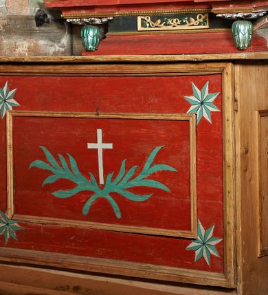 Zdjęcie nr 10: Ołtarz jednokondygnacyjny, jednoosiowy ze zwieńczeniem, ustawiony na mensie. Mensa drewniana, prostopadłościenna, z przodu malowana na czerwono płycina z gorejącym sercem oraz dwiema skrzyżowanymi gałązkami palm w polu. Cokół nastawy flankowany przez dwie rzeźby aniołów; pośrodku obraz „Zaśnięcie Najświętszej Marii Panny” w owalu. Kondygnacja złożona z obrazu z przedstawieniem św. Piotra w kształcie stojącego prostokąta, otoczonego przez bujne wici liści akantu. Nad obrazem herb Szreniawa z syglami w polu tarczy A(NDRZEJ) S(TRZAŁKOWSKI) P(ROBOSZCZ) R(ACŁAWICKI). Tarcza zwieńczona otwartą koroną, nad którą umieszczono skrzydlatą główkę aniołka skierowaną na wprost. W zwieńczeniu ołtarza owalny obraz „Święty Paweł” w ramie z bujnego akantu. U szczytu oraz po bokach zwieńczenia trzy rzeźby aniołów. Struktura polichromowana w kolorze jasnego beżu; detale, ornamentyka i profilowania złocone.
