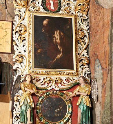 Zdjęcie nr 5: Obraz w kształcie stojącego prostokąta z przedstawieniem św. Piotra. Święty ukazany w centrum kompozycji, w półpostaci, z lewego półprofilu, w dynamicznej pozie, z głową delikatnie przechyloną na lewe ramię, z krzyżem w prawej dłoni, z lewą wyciągniętą do dwóch kluczy leżących na skale obok czaszki. Święty ubrany w czerwony płaszcz odsłaniający nagi tors o silnie podkreślonej muskulaturze. Twarz okolona siwą, długą i bujną brodą; czoło wysokie, pokryte zmarszczkami; na głowie łysina. W górnym, prawym narożu obrazu kogut ukazany z lewego profilu. Tło jednolite, ciemne. Kolorystyka ciemna z przewagą brązów, światłocieniowy modelunek postaci.
