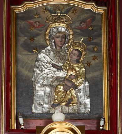 Zdjęcie nr 6: Nastawa ołtarzowa jednokondygnacyjna, jednoosiowa, ze zwieńczeniem, ustawiona na dwustrefowym cokole. Ołtarz prostopadłościenny, z antepedium w kształcie leżącego prostokąta. W polu malowane symbole: skrzyżowane kotwica i krzyż oraz gorejące serce pośrodku. Tabernakulum nowe, w kształcie prostopadłościennej skrzynki z tronem wystawienia, zamkniętym łukiem półkolistym. Na drzwiczkach tabernakulum płaskorzeźbiony kielich i winne grona. Nastawa flankowana parami ukośnie ustawionych i zdwojonych, kanelowanych pilastrów oraz parą stojących przed nimi kolumn o kręconych trzonach. Podpory podtrzymują wyłamane nad osią główną belkowanie, z segmentowymi przyczółkami po bokach. W polu środkowym, w profilowanej ramie, zamkniętej łukiem wklęsło-wypukłym obraz Matki Boskiej Śnieżnej; na zasuwie obraz św. Jakuba Apostoła. Zwieńczenie w kształcie stojącego prostokąta, zamkniętego łukiem nadwieszonym, ujęte po bokach wolutami i zwisami kampanul. W polu płaskorzeźbiona gloria złożona z wiązek promieni o nierównej długości, z monogramem Marii otoczonym obłokami pośrodku. U szczytu korona w typie otwartym. Na przyczółkach oraz na krawędziach zwieńczenia usadzone cztery aniołki w teatralnych pozach. Po bokach nastawy ażurowe uszy złożone z ornamentu rocaille’owego i motywu kratki. Struktura polichromowana w kolorze bordowym, profilowania, ornamentyka i detale złocone i srebrzone.
