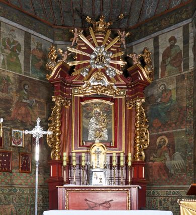Zdjęcie nr 1: Nastawa ołtarzowa jednokondygnacyjna, jednoosiowa, ze zwieńczeniem, ustawiona na dwustrefowym cokole. Ołtarz prostopadłościenny, z antepedium w kształcie leżącego prostokąta. W polu malowane symbole: skrzyżowane kotwica i krzyż oraz gorejące serce pośrodku. Tabernakulum nowe, w kształcie prostopadłościennej skrzynki z tronem wystawienia, zamkniętym łukiem półkolistym. Na drzwiczkach tabernakulum płaskorzeźbiony kielich i winne grona. Nastawa flankowana parami ukośnie ustawionych i zdwojonych, kanelowanych pilastrów oraz parą stojących przed nimi kolumn o kręconych trzonach. Podpory podtrzymują wyłamane nad osią główną belkowanie, z segmentowymi przyczółkami po bokach. W polu środkowym, w profilowanej ramie, zamkniętej łukiem wklęsło-wypukłym obraz Matki Boskiej Śnieżnej; na zasuwie obraz św. Jakuba Apostoła. Zwieńczenie w kształcie stojącego prostokąta, zamkniętego łukiem nadwieszonym, ujęte po bokach wolutami i zwisami kampanul. W polu płaskorzeźbiona gloria złożona z wiązek promieni o nierównej długości, z monogramem Marii otoczonym obłokami pośrodku. U szczytu korona w typie otwartym. Na przyczółkach oraz na krawędziach zwieńczenia usadzone cztery aniołki w teatralnych pozach. Po bokach nastawy ażurowe uszy złożone z ornamentu rocaille’owego i motywu kratki. Struktura polichromowana w kolorze bordowym, profilowania, ornamentyka i detale złocone i srebrzone.
