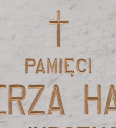 Zdjęcie nr 1: Kamienna tablica w kształcie leżącego prostokąta z wyrytą poniżej krzyża łacińskiego, złocona inskrypcją „+PAMIĘCI / KAZIMIERZA HALLERA / Z JURCZYC / ZAMORDOWANEGO PRZEZ NIEMCÓW / W OŚWIĘCIMIU W R(OKU) 1942 / W 36 R(OKU) ŻYCIA”. W narożach  rozety maskujące miejsca mocowania. 