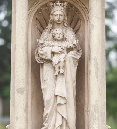 Zdjęcie nr 4: Kapliczka wolnostojąca na wysokim, dwustrefowym cokole. Dolna część szersza, dzielona żłobieniem, z napisem w górnej części „FUNDAROR / SZYMON KOSCIELNY / 1888 r(ok)”. Powyżej węższa, prostopadłościenna część z wyrytą na froncie na kamiennej, wprawionej tablicy inskrypcją „ŚWIĘTA BOŻA RODZICIELKO / MÓDL SIĘ ZA NAMI”. Na prawej ściance bocznej płaskorzeźba z półpostacią św. Szymona Apostoła. Święty zwrócony lekko w prawo, z głową skierowaną w trzech czwartych w tę samą stronę. Ma pociągłą twarz z głęboko osadzonymi oczami, wąskim nosem, niewielkimi ustami przesłoniętymi częściowo wąsami. Twarz okalają zwinięte w pukle włosy i dzieląca się na dwie części broda. Święty lewą ręką przytrzymuje książkę, prawą piłę. Jest ubrany w tunikę z długimi rękawami. Po przeciwnej stronie cokołu podobizna św. Wojciecha ukazanego w podobny sposób. Święty jest ubrany w strój biskupa – komżę, kapę, paliusz i infułę. W prawej ręce trzyma krzyż patriarszy oraz wiosło, lewą przytrzymuje zamkniętą księgę.  Na postumencie ustawiono figurę Marii z Dzieciątkiem w niszy zwieńczonej przyczółkiem wspartym na dwóch kolumnach wychodzących przed jej lico. Maria została przedstawiona całopostaciowo, frontalnie, podtrzymując obiema rękami Dzieciątko, które rozpościera ramiona. Maria ma delikatną, owalną twarz o półprzymkniętych oczach, wąskim nosie i cofniętej brodzie. Długie włosy spływają jej na plecy i ramiona. Jest ubrana w długą suknię i płaszcz z ornamentalna bordiurą. Na głowie ma otwartą koronę. Dzieciątko jest ubrane w tunikę do kolan, ma owalną twarz z głęboko osadzonymi oczami i małym nosem i ustami; włosy opadają puklami na czoło. Niszę wypełnia muszla palmetowa, na gzymsie belkowania rzeźbiona wstęga przepleciona przez uchwyt, gzyms dekorowany kostkowaniem. Półokrągły tympanon wypełniają trzy płyciny – środkowa okrągła, boczne trójkątne o wklęsło-wypukłych krawędziach, powyżej kostkowanie. Na tympanonie, na cokole krucyfiks z wypukle rzeźbioną postacią Chrystusa i titulusem z napisem „INRI”. 