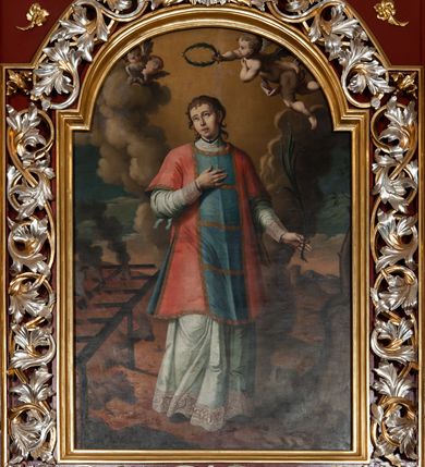 Zdjęcie nr 4: Ołtarz architektoniczny, trójosiowy, jednokondygnacyjny ze zwieńczeniem, na cokole. Mensa prostopadłościenna, drewniana, z portatylem. Antepedium na profilowanej podstawie podzielone na trzy bliskie kwadratom płyciny. Metalowe tabernakulum w formie prostopadłościanu ujętego wolutami z liści. Na ścianie frontowej drzwiczki dekorowane hostią z literami IHS ujętą od dołu rozłożonymi dłońmi.  Osie nastawy wydzielone dwiema parami pilastrów i stojącymi przed licem ołtarza kolumnami z kapitelami kompozytowymi. Wewnętrzna para kolumn dźwiga imposty z przerwanym przyczółkiem, na którym siedzi para klęczących aniołów, zaś zewnętrzna para dźwiga imposty z aniołami półleżącymi. Pole środkowe tworzy szeroka, wypełniona ażurowym akantem i rozetami rama w formie stojącego prostokąta zamkniętego łukiem nadwieszonym, ujęta lizenami, podtrzymywana przez konsole, z obrazem św. Wawrzyńca wymiennie z obrazem św. Józefa oraz rzeźbionym krucyfiksem. W osiach bocznych figury św. Stanisława po lewej i św. Wojciecha po prawej stronie, na tle arkad z ażurową kratką. Zwieńczenie tworzy grupa rzeźbiarska z przedstawieniem Trójcy Świętej. Bóg Ojciec i Chrystus siedzą zwróceni do siebie, na tle ulistionych wolut, które podtrzymują gołębicę Ducha Świetego, nad którą unosi się Oko Opatrzności. Grupa jest flankowana przez jońskie kolumny ze zwróconymi na zewnątrz wolutami, ujęta fragmentami wici tworzącymi spływy wolutowe. Cokoły kolumn dekorowane płycinami z akantem, rozetą i liliami heraldycznymi, zwieńczone ząbkowaniem. W przyłuczach dekoracja roślinna. Płycinę lizen zdobią festony z wstęgą regencyjną. Trzony pilastrów podzielone na dwie płyciny o wklęsłych bokach, dekorowane rozetami. Architrawy i fryzy dekorowane rozetami z akantu, gzyms z ząbkowaniem. Kolumny zwieńczenia dekorowane akantowymi spływami wolutowymi. Ołtarz polichromowany na ciemnoczerwono; ornamentyka oraz detale architektoniczne złocone i srebrzone. 