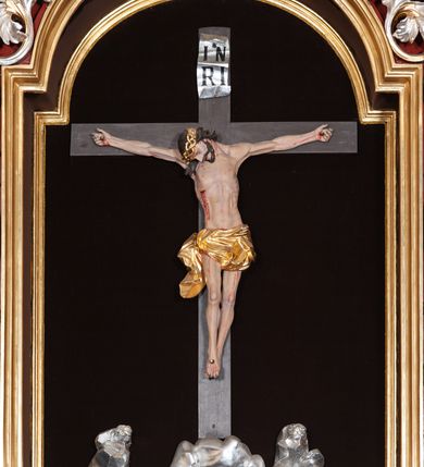 Zdjęcie nr 17: Ołtarz architektoniczny, trójosiowy, jednokondygnacyjny ze zwieńczeniem, na cokole. Mensa prostopadłościenna, drewniana, z portatylem. Antepedium na profilowanej podstawie podzielone na trzy bliskie kwadratom płyciny. Metalowe tabernakulum w formie prostopadłościanu ujętego wolutami z liści. Na ścianie frontowej drzwiczki dekorowane hostią z literami IHS ujętą od dołu rozłożonymi dłońmi.  Osie nastawy wydzielone dwiema parami pilastrów i stojącymi przed licem ołtarza kolumnami z kapitelami kompozytowymi. Wewnętrzna para kolumn dźwiga imposty z przerwanym przyczółkiem, na którym siedzi para klęczących aniołów, zaś zewnętrzna para dźwiga imposty z aniołami półleżącymi. Pole środkowe tworzy szeroka, wypełniona ażurowym akantem i rozetami rama w formie stojącego prostokąta zamkniętego łukiem nadwieszonym, ujęta lizenami, podtrzymywana przez konsole, z obrazem św. Wawrzyńca wymiennie z obrazem św. Józefa oraz rzeźbionym krucyfiksem. W osiach bocznych figury św. Stanisława po lewej i św. Wojciecha po prawej stronie, na tle arkad z ażurową kratką. Zwieńczenie tworzy grupa rzeźbiarska z przedstawieniem Trójcy Świętej. Bóg Ojciec i Chrystus siedzą zwróceni do siebie, na tle ulistionych wolut, które podtrzymują gołębicę Ducha Świetego, nad którą unosi się Oko Opatrzności. Grupa jest flankowana przez jońskie kolumny ze zwróconymi na zewnątrz wolutami, ujęta fragmentami wici tworzącymi spływy wolutowe. Cokoły kolumn dekorowane płycinami z akantem, rozetą i liliami heraldycznymi, zwieńczone ząbkowaniem. W przyłuczach dekoracja roślinna. Płycinę lizen zdobią festony z wstęgą regencyjną. Trzony pilastrów podzielone na dwie płyciny o wklęsłych bokach, dekorowane rozetami. Architrawy i fryzy dekorowane rozetami z akantu, gzyms z ząbkowaniem. Kolumny zwieńczenia dekorowane akantowymi spływami wolutowymi. Ołtarz polichromowany na ciemnoczerwono; ornamentyka oraz detale architektoniczne złocone i srebrzone. 