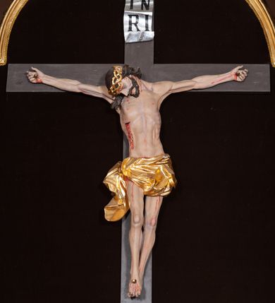 Zdjęcie nr 19: Ołtarz architektoniczny, trójosiowy, jednokondygnacyjny ze zwieńczeniem, na cokole. Mensa prostopadłościenna, drewniana, z portatylem. Antepedium na profilowanej podstawie podzielone na trzy bliskie kwadratom płyciny. Metalowe tabernakulum w formie prostopadłościanu ujętego wolutami z liści. Na ścianie frontowej drzwiczki dekorowane hostią z literami IHS ujętą od dołu rozłożonymi dłońmi.  Osie nastawy wydzielone dwiema parami pilastrów i stojącymi przed licem ołtarza kolumnami z kapitelami kompozytowymi. Wewnętrzna para kolumn dźwiga imposty z przerwanym przyczółkiem, na którym siedzi para klęczących aniołów, zaś zewnętrzna para dźwiga imposty z aniołami półleżącymi. Pole środkowe tworzy szeroka, wypełniona ażurowym akantem i rozetami rama w formie stojącego prostokąta zamkniętego łukiem nadwieszonym, ujęta lizenami, podtrzymywana przez konsole, z obrazem św. Wawrzyńca wymiennie z obrazem św. Józefa oraz rzeźbionym krucyfiksem. W osiach bocznych figury św. Stanisława po lewej i św. Wojciecha po prawej stronie, na tle arkad z ażurową kratką. Zwieńczenie tworzy grupa rzeźbiarska z przedstawieniem Trójcy Świętej. Bóg Ojciec i Chrystus siedzą zwróceni do siebie, na tle ulistionych wolut, które podtrzymują gołębicę Ducha Świetego, nad którą unosi się Oko Opatrzności. Grupa jest flankowana przez jońskie kolumny ze zwróconymi na zewnątrz wolutami, ujęta fragmentami wici tworzącymi spływy wolutowe. Cokoły kolumn dekorowane płycinami z akantem, rozetą i liliami heraldycznymi, zwieńczone ząbkowaniem. W przyłuczach dekoracja roślinna. Płycinę lizen zdobią festony z wstęgą regencyjną. Trzony pilastrów podzielone na dwie płyciny o wklęsłych bokach, dekorowane rozetami. Architrawy i fryzy dekorowane rozetami z akantu, gzyms z ząbkowaniem. Kolumny zwieńczenia dekorowane akantowymi spływami wolutowymi. Ołtarz polichromowany na ciemnoczerwono; ornamentyka oraz detale architektoniczne złocone i srebrzone. 