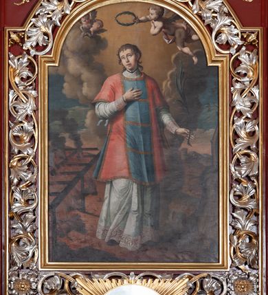 Zdjęcie nr 5: Ołtarz architektoniczny, trójosiowy, jednokondygnacyjny ze zwieńczeniem, na cokole. Mensa prostopadłościenna, drewniana, z portatylem. Antepedium na profilowanej podstawie podzielone na trzy bliskie kwadratom płyciny. Metalowe tabernakulum w formie prostopadłościanu ujętego wolutami z liści. Na ścianie frontowej drzwiczki dekorowane hostią z literami IHS ujętą od dołu rozłożonymi dłońmi.  Osie nastawy wydzielone dwiema parami pilastrów i stojącymi przed licem ołtarza kolumnami z kapitelami kompozytowymi. Wewnętrzna para kolumn dźwiga imposty z przerwanym przyczółkiem, na którym siedzi para klęczących aniołów, zaś zewnętrzna para dźwiga imposty z aniołami półleżącymi. Pole środkowe tworzy szeroka, wypełniona ażurowym akantem i rozetami rama w formie stojącego prostokąta zamkniętego łukiem nadwieszonym, ujęta lizenami, podtrzymywana przez konsole, z obrazem św. Wawrzyńca wymiennie z obrazem św. Józefa oraz rzeźbionym krucyfiksem. W osiach bocznych figury św. Stanisława po lewej i św. Wojciecha po prawej stronie, na tle arkad z ażurową kratką. Zwieńczenie tworzy grupa rzeźbiarska z przedstawieniem Trójcy Świętej. Bóg Ojciec i Chrystus siedzą zwróceni do siebie, na tle ulistionych wolut, które podtrzymują gołębicę Ducha Świetego, nad którą unosi się Oko Opatrzności. Grupa jest flankowana przez jońskie kolumny ze zwróconymi na zewnątrz wolutami, ujęta fragmentami wici tworzącymi spływy wolutowe. Cokoły kolumn dekorowane płycinami z akantem, rozetą i liliami heraldycznymi, zwieńczone ząbkowaniem. W przyłuczach dekoracja roślinna. Płycinę lizen zdobią festony z wstęgą regencyjną. Trzony pilastrów podzielone na dwie płyciny o wklęsłych bokach, dekorowane rozetami. Architrawy i fryzy dekorowane rozetami z akantu, gzyms z ząbkowaniem. Kolumny zwieńczenia dekorowane akantowymi spływami wolutowymi. Ołtarz polichromowany na ciemnoczerwono; ornamentyka oraz detale architektoniczne złocone i srebrzone. 