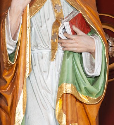 Zdjęcie nr 31: Ołtarz architektoniczny, trójosiowy, jednokondygnacyjny ze zwieńczeniem, na cokole. Mensa prostopadłościenna, drewniana, z portatylem. Antepedium na profilowanej podstawie podzielone na trzy bliskie kwadratom płyciny. Metalowe tabernakulum w formie prostopadłościanu ujętego wolutami z liści. Na ścianie frontowej drzwiczki dekorowane hostią z literami IHS ujętą od dołu rozłożonymi dłońmi.  Osie nastawy wydzielone dwiema parami pilastrów i stojącymi przed licem ołtarza kolumnami z kapitelami kompozytowymi. Wewnętrzna para kolumn dźwiga imposty z przerwanym przyczółkiem, na którym siedzi para klęczących aniołów, zaś zewnętrzna para dźwiga imposty z aniołami półleżącymi. Pole środkowe tworzy szeroka, wypełniona ażurowym akantem i rozetami rama w formie stojącego prostokąta zamkniętego łukiem nadwieszonym, ujęta lizenami, podtrzymywana przez konsole, z obrazem św. Wawrzyńca wymiennie z obrazem św. Józefa oraz rzeźbionym krucyfiksem. W osiach bocznych figury św. Stanisława po lewej i św. Wojciecha po prawej stronie, na tle arkad z ażurową kratką. Zwieńczenie tworzy grupa rzeźbiarska z przedstawieniem Trójcy Świętej. Bóg Ojciec i Chrystus siedzą zwróceni do siebie, na tle ulistionych wolut, które podtrzymują gołębicę Ducha Świetego, nad którą unosi się Oko Opatrzności. Grupa jest flankowana przez jońskie kolumny ze zwróconymi na zewnątrz wolutami, ujęta fragmentami wici tworzącymi spływy wolutowe. Cokoły kolumn dekorowane płycinami z akantem, rozetą i liliami heraldycznymi, zwieńczone ząbkowaniem. W przyłuczach dekoracja roślinna. Płycinę lizen zdobią festony z wstęgą regencyjną. Trzony pilastrów podzielone na dwie płyciny o wklęsłych bokach, dekorowane rozetami. Architrawy i fryzy dekorowane rozetami z akantu, gzyms z ząbkowaniem. Kolumny zwieńczenia dekorowane akantowymi spływami wolutowymi. Ołtarz polichromowany na ciemnoczerwono; ornamentyka oraz detale architektoniczne złocone i srebrzone. 