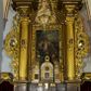 Zdjęcie nr 1: Ołtarz drewniany, architektoniczny, jednoosiowy, jednokondygnacyjny, ze zwieńczeniem, z dwiema bramkami. Jest umieszczony na murowanym, dwustopniowym podwyższeniu. Podstawa ołtarza murowana, skrzyniowa o kształcie prostopadłościanu, o obudowie drewnianej. Brak kamiennej mensy ołtarzowej. W partii antepedium nisza w kształcie prostokąta leżącego. Na mensie ustawione tabernakulum w formie centralnego kościółka zwieńczonego kopułą z latarnią.

Retabulum jest flankowane dwiema złoconymi kolumnami kompozytowymi, ustawionymi na profilowanych cokołach. Trzony kolumn są kanelowane, ozdobione w połowie wysokości główkami aniołków ujętymi dekoracją chrząstkową. Kolumny dźwigają belkowanie z wydatnym, przełamującym się nad nimi gzymsem, ozdobione ornamentem małżowinowym. W polu środkowym ołtarza profilowana, złocona i malowana rama z górną krawędzią w formie arkady z kluczem, dolna krawędź zaakcentowana uskokiem. W niej druga rama, prostokątna, ozdobiona ornamentem małżowinowym i złocona, z obrazem przedstawiającym Św. Annę Samotrzeć w otoczeniu świętych. We wnęce, za zasuwą, widnieje obraz Matki Boskiej z Dzieciątkiem w prostokątnej ramie, rzeźbionej i złoconej, pokrytej ornamentem roślinnym. Wnęka pokryta ciemnoczerwonym aksamitem, poniżej obrazu zawieszone wota. W polu arkady, w półkolistym tympanonie, na tle złoconych obłoków srebrna gołębica Ducha Świętego. Na gzymsie, na osi kolumn wazony z kwiatami. Po bokach retabulum bogato rzeźbione i złocone uszy z bujnym ornamentem małżowinowym. W zwieńczeniu, w owalnej, profilowanej i złoconej ramie obraz przedstawiający Wniebowzięcie Najświętszej Marii Panny. Rama otoczona szeroko rozbudowaną ornamentyką małżowinową. Po bokach ołtarza bramki prowadzące za ołtarz, o kształcie prostokąta stojącego, ze zwieńczeniem w formie łuku kotarowego zamkniętego od góry prostym odcinkiem, z profilowanym cokołem (pod figurę) z podwieszonym ornamentem w kształcie muszli. Górne narożniki bramek podkreślone złoconym ornamentem w kształcie wolut z elementem roślinnym. Otwór wejściowy, w kształcie analogicznym do bramki, z profilowanymi krawędziami, zakryty kotarą z aksamitu w kolorze ciemnoczerwonym. Struktura ołtarza polichromowana w kolorze ciemnobrązowym. Kolumny, pilastry, profilowania i dekoracja rzeźbiarska złocone.
