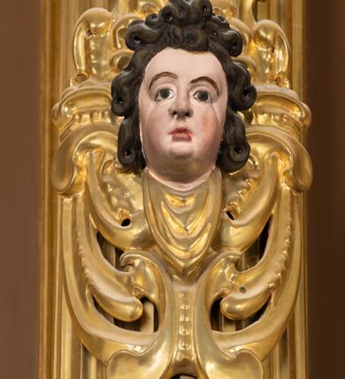 Zdjęcie nr 14: Ołtarz drewniany, architektoniczny, jednoosiowy, jednokondygnacyjny, ze zwieńczeniem, z dwiema bramkami. Jest umieszczony na murowanym, dwustopniowym podwyższeniu. Podstawa ołtarza murowana, skrzyniowa o kształcie prostopadłościanu, o obudowie drewnianej. Brak kamiennej mensy ołtarzowej. W partii antepedium nisza w kształcie prostokąta leżącego. Na mensie ustawione tabernakulum w formie centralnego kościółka zwieńczonego kopułą z latarnią.

Retabulum jest flankowane dwiema złoconymi kolumnami kompozytowymi, ustawionymi na profilowanych cokołach. Trzony kolumn są kanelowane, ozdobione w połowie wysokości główkami aniołków ujętymi dekoracją chrząstkową. Kolumny dźwigają belkowanie z wydatnym, przełamującym się nad nimi gzymsem, ozdobione ornamentem małżowinowym. W polu środkowym ołtarza profilowana, złocona i malowana rama z górną krawędzią w formie arkady z kluczem, dolna krawędź zaakcentowana uskokiem. W niej druga rama, prostokątna, ozdobiona ornamentem małżowinowym i złocona, z obrazem przedstawiającym Św. Annę Samotrzeć w otoczeniu świętych. We wnęce, za zasuwą, widnieje obraz Matki Boskiej z Dzieciątkiem w prostokątnej ramie, rzeźbionej i złoconej, pokrytej ornamentem roślinnym. Wnęka pokryta ciemnoczerwonym aksamitem, poniżej obrazu zawieszone wota. W polu arkady, w półkolistym tympanonie, na tle złoconych obłoków srebrna gołębica Ducha Świętego. Na gzymsie, na osi kolumn wazony z kwiatami. Po bokach retabulum bogato rzeźbione i złocone uszy z bujnym ornamentem małżowinowym. W zwieńczeniu, w owalnej, profilowanej i złoconej ramie obraz przedstawiający Wniebowzięcie Najświętszej Marii Panny. Rama otoczona szeroko rozbudowaną ornamentyką małżowinową. Po bokach ołtarza bramki prowadzące za ołtarz, o kształcie prostokąta stojącego, ze zwieńczeniem w formie łuku kotarowego zamkniętego od góry prostym odcinkiem, z profilowanym cokołem (pod figurę) z podwieszonym ornamentem w kształcie muszli. Górne narożniki bramek podkreślone złoconym ornamentem w kształcie wolut z elementem roślinnym. Otwór wejściowy, w kształcie analogicznym do bramki, z profilowanymi krawędziami, zakryty kotarą z aksamitu w kolorze ciemnoczerwonym. Struktura ołtarza polichromowana w kolorze ciemnobrązowym. Kolumny, pilastry, profilowania i dekoracja rzeźbiarska złocone.