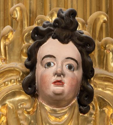 Zdjęcie nr 17: Ołtarz drewniany, architektoniczny, jednoosiowy, jednokondygnacyjny, ze zwieńczeniem, z dwiema bramkami. Jest umieszczony na murowanym, dwustopniowym podwyższeniu. Podstawa ołtarza murowana, skrzyniowa o kształcie prostopadłościanu, o obudowie drewnianej. Brak kamiennej mensy ołtarzowej. W partii antepedium nisza w kształcie prostokąta leżącego. Na mensie ustawione tabernakulum w formie centralnego kościółka zwieńczonego kopułą z latarnią.

Retabulum jest flankowane dwiema złoconymi kolumnami kompozytowymi, ustawionymi na profilowanych cokołach. Trzony kolumn są kanelowane, ozdobione w połowie wysokości główkami aniołków ujętymi dekoracją chrząstkową. Kolumny dźwigają belkowanie z wydatnym, przełamującym się nad nimi gzymsem, ozdobione ornamentem małżowinowym. W polu środkowym ołtarza profilowana, złocona i malowana rama z górną krawędzią w formie arkady z kluczem, dolna krawędź zaakcentowana uskokiem. W niej druga rama, prostokątna, ozdobiona ornamentem małżowinowym i złocona, z obrazem przedstawiającym Św. Annę Samotrzeć w otoczeniu świętych. We wnęce, za zasuwą, widnieje obraz Matki Boskiej z Dzieciątkiem w prostokątnej ramie, rzeźbionej i złoconej, pokrytej ornamentem roślinnym. Wnęka pokryta ciemnoczerwonym aksamitem, poniżej obrazu zawieszone wota. W polu arkady, w półkolistym tympanonie, na tle złoconych obłoków srebrna gołębica Ducha Świętego. Na gzymsie, na osi kolumn wazony z kwiatami. Po bokach retabulum bogato rzeźbione i złocone uszy z bujnym ornamentem małżowinowym. W zwieńczeniu, w owalnej, profilowanej i złoconej ramie obraz przedstawiający Wniebowzięcie Najświętszej Marii Panny. Rama otoczona szeroko rozbudowaną ornamentyką małżowinową. Po bokach ołtarza bramki prowadzące za ołtarz, o kształcie prostokąta stojącego, ze zwieńczeniem w formie łuku kotarowego zamkniętego od góry prostym odcinkiem, z profilowanym cokołem (pod figurę) z podwieszonym ornamentem w kształcie muszli. Górne narożniki bramek podkreślone złoconym ornamentem w kształcie wolut z elementem roślinnym. Otwór wejściowy, w kształcie analogicznym do bramki, z profilowanymi krawędziami, zakryty kotarą z aksamitu w kolorze ciemnoczerwonym. Struktura ołtarza polichromowana w kolorze ciemnobrązowym. Kolumny, pilastry, profilowania i dekoracja rzeźbiarska złocone.