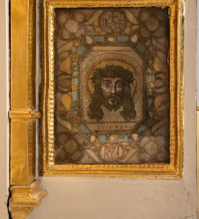 Zdjęcie nr 31: Ołtarz drewniany, architektoniczny, jednoosiowy, jednokondygnacyjny, ze zwieńczeniem, z dwiema bramkami. Jest umieszczony na murowanym, dwustopniowym podwyższeniu. Podstawa ołtarza murowana, skrzyniowa o kształcie prostopadłościanu, o obudowie drewnianej. Brak kamiennej mensy ołtarzowej. W partii antepedium nisza w kształcie prostokąta leżącego. Na mensie ustawione tabernakulum w formie centralnego kościółka zwieńczonego kopułą z latarnią.

Retabulum jest flankowane dwiema złoconymi kolumnami kompozytowymi, ustawionymi na profilowanych cokołach. Trzony kolumn są kanelowane, ozdobione w połowie wysokości główkami aniołków ujętymi dekoracją chrząstkową. Kolumny dźwigają belkowanie z wydatnym, przełamującym się nad nimi gzymsem, ozdobione ornamentem małżowinowym. W polu środkowym ołtarza profilowana, złocona i malowana rama z górną krawędzią w formie arkady z kluczem, dolna krawędź zaakcentowana uskokiem. W niej druga rama, prostokątna, ozdobiona ornamentem małżowinowym i złocona, z obrazem przedstawiającym Św. Annę Samotrzeć w otoczeniu świętych. We wnęce, za zasuwą, widnieje obraz Matki Boskiej z Dzieciątkiem w prostokątnej ramie, rzeźbionej i złoconej, pokrytej ornamentem roślinnym. Wnęka pokryta ciemnoczerwonym aksamitem, poniżej obrazu zawieszone wota. W polu arkady, w półkolistym tympanonie, na tle złoconych obłoków srebrna gołębica Ducha Świętego. Na gzymsie, na osi kolumn wazony z kwiatami. Po bokach retabulum bogato rzeźbione i złocone uszy z bujnym ornamentem małżowinowym. W zwieńczeniu, w owalnej, profilowanej i złoconej ramie obraz przedstawiający Wniebowzięcie Najświętszej Marii Panny. Rama otoczona szeroko rozbudowaną ornamentyką małżowinową. Po bokach ołtarza bramki prowadzące za ołtarz, o kształcie prostokąta stojącego, ze zwieńczeniem w formie łuku kotarowego zamkniętego od góry prostym odcinkiem, z profilowanym cokołem (pod figurę) z podwieszonym ornamentem w kształcie muszli. Górne narożniki bramek podkreślone złoconym ornamentem w kształcie wolut z elementem roślinnym. Otwór wejściowy, w kształcie analogicznym do bramki, z profilowanymi krawędziami, zakryty kotarą z aksamitu w kolorze ciemnoczerwonym. Struktura ołtarza polichromowana w kolorze ciemnobrązowym. Kolumny, pilastry, profilowania i dekoracja rzeźbiarska złocone.