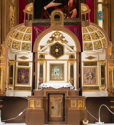 Zdjęcie nr 35: Ołtarz drewniany, architektoniczny, jednoosiowy, jednokondygnacyjny, ze zwieńczeniem, z dwiema bramkami. Jest umieszczony na murowanym, dwustopniowym podwyższeniu. Podstawa ołtarza murowana, skrzyniowa o kształcie prostopadłościanu, o obudowie drewnianej. Brak kamiennej mensy ołtarzowej. W partii antepedium nisza w kształcie prostokąta leżącego. Na mensie ustawione tabernakulum w formie centralnego kościółka zwieńczonego kopułą z latarnią.

Retabulum jest flankowane dwiema złoconymi kolumnami kompozytowymi, ustawionymi na profilowanych cokołach. Trzony kolumn są kanelowane, ozdobione w połowie wysokości główkami aniołków ujętymi dekoracją chrząstkową. Kolumny dźwigają belkowanie z wydatnym, przełamującym się nad nimi gzymsem, ozdobione ornamentem małżowinowym. W polu środkowym ołtarza profilowana, złocona i malowana rama z górną krawędzią w formie arkady z kluczem, dolna krawędź zaakcentowana uskokiem. W niej druga rama, prostokątna, ozdobiona ornamentem małżowinowym i złocona, z obrazem przedstawiającym Św. Annę Samotrzeć w otoczeniu świętych. We wnęce, za zasuwą, widnieje obraz Matki Boskiej z Dzieciątkiem w prostokątnej ramie, rzeźbionej i złoconej, pokrytej ornamentem roślinnym. Wnęka pokryta ciemnoczerwonym aksamitem, poniżej obrazu zawieszone wota. W polu arkady, w półkolistym tympanonie, na tle złoconych obłoków srebrna gołębica Ducha Świętego. Na gzymsie, na osi kolumn wazony z kwiatami. Po bokach retabulum bogato rzeźbione i złocone uszy z bujnym ornamentem małżowinowym. W zwieńczeniu, w owalnej, profilowanej i złoconej ramie obraz przedstawiający Wniebowzięcie Najświętszej Marii Panny. Rama otoczona szeroko rozbudowaną ornamentyką małżowinową. Po bokach ołtarza bramki prowadzące za ołtarz, o kształcie prostokąta stojącego, ze zwieńczeniem w formie łuku kotarowego zamkniętego od góry prostym odcinkiem, z profilowanym cokołem (pod figurę) z podwieszonym ornamentem w kształcie muszli. Górne narożniki bramek podkreślone złoconym ornamentem w kształcie wolut z elementem roślinnym. Otwór wejściowy, w kształcie analogicznym do bramki, z profilowanymi krawędziami, zakryty kotarą z aksamitu w kolorze ciemnoczerwonym. Struktura ołtarza polichromowana w kolorze ciemnobrązowym. Kolumny, pilastry, profilowania i dekoracja rzeźbiarska złocone.