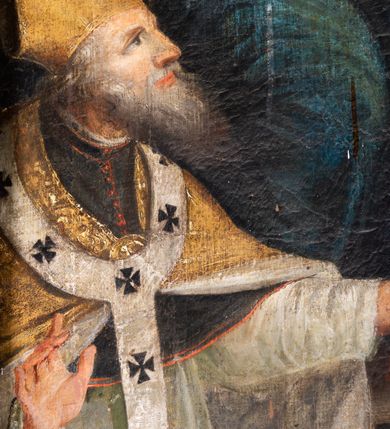 Zdjęcie nr 14: Obraz w kształcie stojącego prostokąta, w ramie rzeźbionej, malowanej, złoconej i ozdobionej ornamentem małżowinowym. Ukazuje św. Annę, Marię i Jezusa oraz świętych Wojciecha, Stanisława, Katarzynę i Tomasza. Na dwudzielnej ławie umieszczonej na podwyższeniu siedzi: po lewej stronie Najświętsza Maria Panna, po prawej św. Anna. Obie niewiasty zwrócone są ku stojącemu pomiędzy nimi Dzieciątku. Nagi Chrystus, okryty na skos białą chustą, przytrzymywaną na Jego prawym boku przez obie niewiasty, ukazany frontalnie, z wysuniętą ku przodowi prawą nóżką i lewą podtrzymywaną przez św. Annę. Prawą rękę wznosi w geście błogosławieństwa, zaś lewa obejmuje św. Annę. Głowę Chrystusa, ozdobioną jasno złotobrązowymi włosami, otacza promienista gloria. 
Najświętsza Maria Panna, lekko pochylona w kierunku Chrystusa, ubrana jest w czerwoną suknię i niebieski płaszcz założony na lewe ramię. Jej głowa jest nakryta jasnozieloną chustą, związaną z tyłu głowy, spod której wyłaniają się jasnobrązowe włosy. Twarz Marii zwrócona jest ku widzowi, ze wzrokiem skierowanym na wprost. Święta Anna w zielonej sukni i ciemnoczerwonym płaszczu, narzuconym na prawe ramię mocno pochyla się ku Chrystusowi. Głowę świętej przykrywa biała chusta ze złotymi przeszyciami, opadająca na plecy i prawe ramię. Spod chusty widoczne siwe włosy. Twarz św. Anny ukazana jest półprofilu, ze wzrokiem skierowanym ku Marii. Nad głowami Marii i św. Anny unoszą się nimby. Na pierwszym planie, u stóp niewiast klęczą zwróceni ku Jezusowi: po lewej stronie św. Wojciech w stroju biskupim, z paliuszem i z leżącym przed nim na ziemi pastorałem z podwójnym krzyżem, po prawej św. Stanisław, w stroju biskupim, z pastorałem w lewej ręce i postacią Piotrowina wyłaniającą się z grobu. W tle po prawej stronie św. Katarzyna, trzymająca miecz we wspartej na kole prawej dłoni i palmę męczeństwa w lewej, ubrana w zielona suknię i szary płaszcz. Obok niej stoi św. Tomasz, z prawą dłonią złożoną na piersi, z lilią w lewej ręce, ubrany w czarny habit. Za postaciami świętych daleki górski pejzaż. Po lewej stronie obrazu, na tle architektury z podwieszonymi ciemnoniebieskimi kotarami ozdobionymi złocistymi frędzlami i chwostem, widnieją popiersia dwóch świętych starców w jasnobrązowych szatach. Głowy świętych otaczają nimby. W górnej części, na osi obrazu popiersie Boga Ojca z trójkątnym nimbem, poniżej gołębica Ducha Świętego, otoczona promienistą glorią. Kolorystyka obrazu stonowana, ciepła, nasycona. Kolorystyczną dominantę stanowi ciemny błękit płaszcza Marii, czerwień płaszcza i zieleń sukni św. Anny. Kolory te podkreślają jasną postać Chrystusa.
