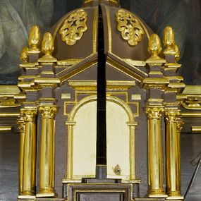 Zdjęcie nr 1: Tabernakulum w formie centralnego kościoła z kopułą. Całość na wysokim profilowanym cokole, flankującym właściwe Sakramentarium, z drzwiczkami w kształcie stojącego prostokąta, ozdobionymi płyciną z uszakami w górnych narożnikach, ujętymi od góry nadwieszonym prostokątnym profilowanym obramieniem. Na cokole cztery pary kolumn korynckich ustawionych uskokowo, flankujących centralną arkadę zakończoną łukiem półkolistym. Kolumny dźwigają belkowanie z wydatnym przełamującym się gzymsem, zwieńczone trójkątnym profilowanym przyczółkiem. Ponad kolumnami, ustawione na profilowanych impostach dekoracyjne szyszki. Kopuła z pionowymi podziałami, ozdobionymi ornamentem małżowinowym, zwieńczona latarnią z przeźroczami w postaci półkolistych arkad i kopułką. Całość zwieńczona krzyżem o ramionach zakończonych trójliściem. 
Górna część tabernakulum wraz z kopułą otwierana drzwiczkami dwuskrzydłowymi, łamanymi, dwuelementowymi. Wewnątrz na ścianach podziały architektoniczne zaznaczone korynckimi pilastrami wspierającymi belkowanie, ustawionymi na wysokich cokołach. W części środkowej pilastry dźwigają belkowanie z przełamującym się gzymsem i zwieńczeniem trójkątnym przerwanym, ozdobionym motywem złożonym z ornamentu małżowinowego. W polu tympanonu i belkowania rozeta inkrustowana bursztynem, ujęta ramą w kształcie sześcioboku. Na ścianach wewnętrznych obrazki relikwiarzowe, w profilowanych ramach, oszklone. W środkowym przedstawienie św. Katarzyny Sieneńskiej z aniołami, nad nim owalne pole wpisane w oktagon z owalną kasztą obwiedzione kwiatami i glorią promienistą, w kwiatach wydrukowane słowa: "AGNUS OMBRA DE [...]". Na dwóch lewych ściankach tkany wizerunek Matki Boskiej Krakowskiej z podpisem: " IMAGO M. MIRACVLOSA B(EATAE) V(IRGINIS) M(ARIAE) / IN ECCLESIA CARMELITA/NVM CRACOVIE IN ARENIS" oraz relikwie w owalnej kaszcie obwiedzionej abstrakcyjnym, symetrycznym wzorem wykonanym z metalowych blaszek. Na ściankach z prawej strony owalne przedstawienie św. Katarzyny Aleksandryjskiej otoczone stylizowanymi wiciami z blaszek i relikwiami wielu świętych opisanych na banderolach oraz przedstawienie Ecce Homo z podpisem "ECCE HOMO" i monogramem imienia Jezus (u góry) i maryjsnym (u dołu). Podniebie kopuły wypełnione perspektywicznymi kasetonami ozdobionymi ornamentem małżowinowym. Struktura tabernakulum w kolorze ciemnobrązowym, pola arkady, płyciny i pola wewnętrzne jasnobeżowe, pola kasetonów niebieskie, kolumny, pilastry, profilowania i ornamenty złocone.