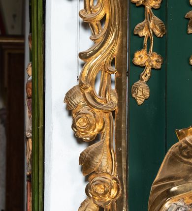Zdjęcie nr 8: Ołtarz przyścienny, architektoniczny, jednokondygnacyjny, jednoosiowy ze zwieńczeniem. Umieszczony na dwustopniowym, kamiennym podwyższeniu. Mensa prostopadłościenna, z portatylem i współczesnym antepedium ozdobionym postacią św. Weroniki trzymającej chustę z odbiciem twarzy Chrystusa (veraikon) i rzeźbionym ornamentem ze srebrzonych liści i złoconych kiści winogron; tło w kolorze struktury ołtarza. Retabulum na wysokim profilowanym, dwustopniowym cokole, flankowane zwielokrotnionymi pilastrami z jońskimi kapitelami. Pilastry dźwigają przerwane belkowanie z wydatnym profilowanym gzymsem z przerwanym przyczółkiem. Zwieńczenie o wklęsłych bokach ujęte spływami wolutowymi dźwigającymi gzyms w formie nadwieszonego łuku odcinkowego. Na tle pilastrów ustawione na profilowanych impostach rzeźby: po prawej stronie św. Wojciecha, po lewej św. Stanisława. Na przyczółkach znajdują się siedzące putta. Pole środkowe o kształcie prostokąta stojącego od góry zamkniętego łukiem półkolistym nadwieszonym, w kluczu ornament z motywu rocaille. Wewnątrz pola ujęty profilowaną, złoconą ramą obraz z przedstawieniem św. Mikołaja z Miry. W zwieńczeniu obraz w ramie z wklęsłymi bokami i wypukłymi dolną i górną krawędzią przedstawiający św. Marię Magdalenę. Nastawę ujmują ornamentalne uszy, utworzone z motywów rocaille'owych i liściasto-kwiatowych zwisów. Na kapitele są nałożone rocaille'owe kartusze, a pod nimi podwieszone zwisające ulistnione i ukwiecone gałązki wzbogacone motywami rocaille'ów. Struktura ołtarza polichromowana w kolorze ciemnozielonym. Bazy pilastrów, kapitele, uszy, ornamenty, profilowania, obramienia płycin i ramy obrazów złocone. Rzeźby świętych złocone, srebrzone i polichromowane. Rzeźby aniołków złocone i polichromowane.


