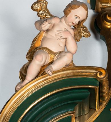 Zdjęcie nr 9: Ołtarz przyścienny, architektoniczny, jednokondygnacyjny, jednoosiowy ze zwieńczeniem. Umieszczony na dwustopniowym, kamiennym podwyższeniu. Mensa prostopadłościenna, z portatylem i współczesnym antepedium ozdobionym postacią św. Weroniki trzymającej chustę z odbiciem twarzy Chrystusa (veraikon) i rzeźbionym ornamentem ze srebrzonych liści i złoconych kiści winogron; tło w kolorze struktury ołtarza. Retabulum na wysokim profilowanym, dwustopniowym cokole, flankowane zwielokrotnionymi pilastrami z jońskimi kapitelami. Pilastry dźwigają przerwane belkowanie z wydatnym profilowanym gzymsem z przerwanym przyczółkiem. Zwieńczenie o wklęsłych bokach ujęte spływami wolutowymi dźwigającymi gzyms w formie nadwieszonego łuku odcinkowego. Na tle pilastrów ustawione na profilowanych impostach rzeźby: po prawej stronie św. Wojciecha, po lewej św. Stanisława. Na przyczółkach znajdują się siedzące putta. Pole środkowe o kształcie prostokąta stojącego od góry zamkniętego łukiem półkolistym nadwieszonym, w kluczu ornament z motywu rocaille. Wewnątrz pola ujęty profilowaną, złoconą ramą obraz z przedstawieniem św. Mikołaja z Miry. W zwieńczeniu obraz w ramie z wklęsłymi bokami i wypukłymi dolną i górną krawędzią przedstawiający św. Marię Magdalenę. Nastawę ujmują ornamentalne uszy, utworzone z motywów rocaille'owych i liściasto-kwiatowych zwisów. Na kapitele są nałożone rocaille'owe kartusze, a pod nimi podwieszone zwisające ulistnione i ukwiecone gałązki wzbogacone motywami rocaille'ów. Struktura ołtarza polichromowana w kolorze ciemnozielonym. Bazy pilastrów, kapitele, uszy, ornamenty, profilowania, obramienia płycin i ramy obrazów złocone. Rzeźby świętych złocone, srebrzone i polichromowane. Rzeźby aniołków złocone i polichromowane.

