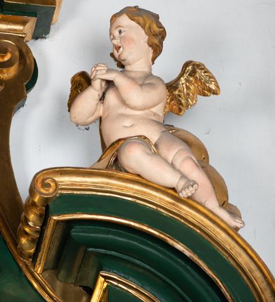 Zdjęcie nr 5: Ołtarz przyścienny, architektoniczny, jednokondygnacyjny, jednoosiowy ze zwieńczeniem. Umieszczony na dwustopniowym, kamiennym podwyższeniu. Mensa prostopadłościenna, z portatylem i współczesnym antepedium ozdobionym postacią św. Weroniki trzymającej chustę z odbiciem twarzy Chrystusa (veraikon) i rzeźbionym ornamentem ze srebrzonych liści i złoconych kiści winogron; tło w kolorze struktury ołtarza. Retabulum na wysokim profilowanym, dwustopniowym cokole, flankowane zwielokrotnionymi pilastrami z jońskimi kapitelami. Pilastry dźwigają przerwane belkowanie z wydatnym profilowanym gzymsem z przerwanym przyczółkiem. Zwieńczenie o wklęsłych bokach ujęte spływami wolutowymi dźwigającymi gzyms w formie nadwieszonego łuku odcinkowego. Na tle pilastrów ustawione na profilowanych impostach rzeźby: po prawej stronie św. Wojciecha, po lewej św. Stanisława. Na przyczółkach znajdują się siedzące putta. Pole środkowe o kształcie prostokąta stojącego od góry zamkniętego łukiem półkolistym nadwieszonym, w kluczu ornament z motywu rocaille. Wewnątrz pola ujęty profilowaną, złoconą ramą obraz z przedstawieniem św. Mikołaja z Miry. W zwieńczeniu obraz w ramie z wklęsłymi bokami i wypukłymi dolną i górną krawędzią przedstawiający św. Marię Magdalenę. Nastawę ujmują ornamentalne uszy, utworzone z motywów rocaille'owych i liściasto-kwiatowych zwisów. Na kapitele są nałożone rocaille'owe kartusze, a pod nimi podwieszone zwisające ulistnione i ukwiecone gałązki wzbogacone motywami rocaille'ów. Struktura ołtarza polichromowana w kolorze ciemnozielonym. Bazy pilastrów, kapitele, uszy, ornamenty, profilowania, obramienia płycin i ramy obrazów złocone. Rzeźby świętych złocone, srebrzone i polichromowane. Rzeźby aniołków złocone i polichromowane.

