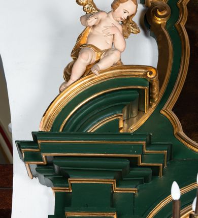 Zdjęcie nr 10: Ołtarz przyścienny, architektoniczny, jednokondygnacyjny, jednoosiowy ze zwieńczeniem. Umieszczony na dwustopniowym, kamiennym podwyższeniu. Mensa prostopadłościenna, z portatylem i współczesnym antepedium ozdobionym postacią św. Weroniki trzymającej chustę z odbiciem twarzy Chrystusa (veraikon) i rzeźbionym ornamentem ze srebrzonych liści i złoconych kiści winogron; tło w kolorze struktury ołtarza. Retabulum na wysokim profilowanym, dwustopniowym cokole, flankowane zwielokrotnionymi pilastrami z jońskimi kapitelami. Pilastry dźwigają przerwane belkowanie z wydatnym profilowanym gzymsem z przerwanym przyczółkiem. Zwieńczenie o wklęsłych bokach ujęte spływami wolutowymi dźwigającymi gzyms w formie nadwieszonego łuku odcinkowego. Na tle pilastrów ustawione na profilowanych impostach rzeźby: po prawej stronie św. Wojciecha, po lewej św. Stanisława. Na przyczółkach znajdują się siedzące putta. Pole środkowe o kształcie prostokąta stojącego od góry zamkniętego łukiem półkolistym nadwieszonym, w kluczu ornament z motywu rocaille. Wewnątrz pola ujęty profilowaną, złoconą ramą obraz z przedstawieniem św. Mikołaja z Miry. W zwieńczeniu obraz w ramie z wklęsłymi bokami i wypukłymi dolną i górną krawędzią przedstawiający św. Marię Magdalenę. Nastawę ujmują ornamentalne uszy, utworzone z motywów rocaille'owych i liściasto-kwiatowych zwisów. Na kapitele są nałożone rocaille'owe kartusze, a pod nimi podwieszone zwisające ulistnione i ukwiecone gałązki wzbogacone motywami rocaille'ów. Struktura ołtarza polichromowana w kolorze ciemnozielonym. Bazy pilastrów, kapitele, uszy, ornamenty, profilowania, obramienia płycin i ramy obrazów złocone. Rzeźby świętych złocone, srebrzone i polichromowane. Rzeźby aniołków złocone i polichromowane.

