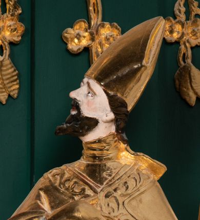 Zdjęcie nr 26: Ołtarz przyścienny, architektoniczny, jednokondygnacyjny, jednoosiowy ze zwieńczeniem. Umieszczony na dwustopniowym, kamiennym podwyższeniu. Mensa prostopadłościenna, z portatylem i współczesnym antepedium ozdobionym postacią św. Weroniki trzymającej chustę z odbiciem twarzy Chrystusa (veraikon) i rzeźbionym ornamentem ze srebrzonych liści i złoconych kiści winogron; tło w kolorze struktury ołtarza. Retabulum na wysokim profilowanym, dwustopniowym cokole, flankowane zwielokrotnionymi pilastrami z jońskimi kapitelami. Pilastry dźwigają przerwane belkowanie z wydatnym profilowanym gzymsem z przerwanym przyczółkiem. Zwieńczenie o wklęsłych bokach ujęte spływami wolutowymi dźwigającymi gzyms w formie nadwieszonego łuku odcinkowego. Na tle pilastrów ustawione na profilowanych impostach rzeźby: po prawej stronie św. Wojciecha, po lewej św. Stanisława. Na przyczółkach znajdują się siedzące putta. Pole środkowe o kształcie prostokąta stojącego od góry zamkniętego łukiem półkolistym nadwieszonym, w kluczu ornament z motywu rocaille. Wewnątrz pola ujęty profilowaną, złoconą ramą obraz z przedstawieniem św. Mikołaja z Miry. W zwieńczeniu obraz w ramie z wklęsłymi bokami i wypukłymi dolną i górną krawędzią przedstawiający św. Marię Magdalenę. Nastawę ujmują ornamentalne uszy, utworzone z motywów rocaille&#039;owych i liściasto-kwiatowych zwisów. Na kapitele są nałożone rocaille&#039;owe kartusze, a pod nimi podwieszone zwisające ulistnione i ukwiecone gałązki wzbogacone motywami rocaille&#039;ów. Struktura ołtarza polichromowana w kolorze ciemnozielonym. Bazy pilastrów, kapitele, uszy, ornamenty, profilowania, obramienia płycin i ramy obrazów złocone. Rzeźby świętych złocone, srebrzone i polichromowane. Rzeźby aniołków złocone i polichromowane.

