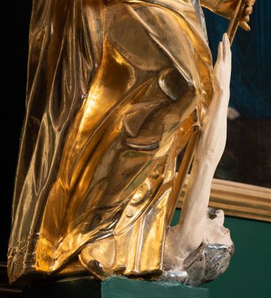 Zdjęcie nr 32: Ołtarz przyścienny, architektoniczny, jednokondygnacyjny, jednoosiowy ze zwieńczeniem. Umieszczony na dwustopniowym, kamiennym podwyższeniu. Mensa prostopadłościenna, z portatylem i współczesnym antepedium ozdobionym postacią św. Weroniki trzymającej chustę z odbiciem twarzy Chrystusa (veraikon) i rzeźbionym ornamentem ze srebrzonych liści i złoconych kiści winogron; tło w kolorze struktury ołtarza. Retabulum na wysokim profilowanym, dwustopniowym cokole, flankowane zwielokrotnionymi pilastrami z jońskimi kapitelami. Pilastry dźwigają przerwane belkowanie z wydatnym profilowanym gzymsem z przerwanym przyczółkiem. Zwieńczenie o wklęsłych bokach ujęte spływami wolutowymi dźwigającymi gzyms w formie nadwieszonego łuku odcinkowego. Na tle pilastrów ustawione na profilowanych impostach rzeźby: po prawej stronie św. Wojciecha, po lewej św. Stanisława. Na przyczółkach znajdują się siedzące putta. Pole środkowe o kształcie prostokąta stojącego od góry zamkniętego łukiem półkolistym nadwieszonym, w kluczu ornament z motywu rocaille. Wewnątrz pola ujęty profilowaną, złoconą ramą obraz z przedstawieniem św. Mikołaja z Miry. W zwieńczeniu obraz w ramie z wklęsłymi bokami i wypukłymi dolną i górną krawędzią przedstawiający św. Marię Magdalenę. Nastawę ujmują ornamentalne uszy, utworzone z motywów rocaille'owych i liściasto-kwiatowych zwisów. Na kapitele są nałożone rocaille'owe kartusze, a pod nimi podwieszone zwisające ulistnione i ukwiecone gałązki wzbogacone motywami rocaille'ów. Struktura ołtarza polichromowana w kolorze ciemnozielonym. Bazy pilastrów, kapitele, uszy, ornamenty, profilowania, obramienia płycin i ramy obrazów złocone. Rzeźby świętych złocone, srebrzone i polichromowane. Rzeźby aniołków złocone i polichromowane.

