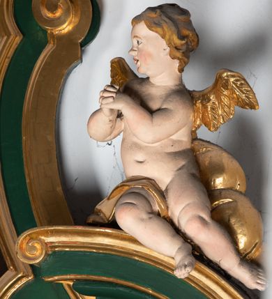 Zdjęcie nr 46: Ołtarz przyścienny, architektoniczny, jednokondygnacyjny, jednoosiowy ze zwieńczeniem. Umieszczony na dwustopniowym, kamiennym podwyższeniu. Mensa prostopadłościenna, z portatylem i współczesnym antepedium ozdobionym postacią św. Weroniki trzymającej chustę z odbiciem twarzy Chrystusa (veraikon) i rzeźbionym ornamentem ze srebrzonych liści i złoconych kiści winogron; tło w kolorze struktury ołtarza. Retabulum na wysokim profilowanym, dwustopniowym cokole, flankowane zwielokrotnionymi pilastrami z jońskimi kapitelami. Pilastry dźwigają przerwane belkowanie z wydatnym profilowanym gzymsem z przerwanym przyczółkiem. Zwieńczenie o wklęsłych bokach ujęte spływami wolutowymi dźwigającymi gzyms w formie nadwieszonego łuku odcinkowego. Na tle pilastrów ustawione na profilowanych impostach rzeźby: po prawej stronie św. Wojciecha, po lewej św. Stanisława. Na przyczółkach znajdują się siedzące putta. Pole środkowe o kształcie prostokąta stojącego od góry zamkniętego łukiem półkolistym nadwieszonym, w kluczu ornament z motywu rocaille. Wewnątrz pola ujęty profilowaną, złoconą ramą obraz z przedstawieniem św. Mikołaja z Miry. W zwieńczeniu obraz w ramie z wklęsłymi bokami i wypukłymi dolną i górną krawędzią przedstawiający św. Marię Magdalenę. Nastawę ujmują ornamentalne uszy, utworzone z motywów rocaille&#039;owych i liściasto-kwiatowych zwisów. Na kapitele są nałożone rocaille&#039;owe kartusze, a pod nimi podwieszone zwisające ulistnione i ukwiecone gałązki wzbogacone motywami rocaille&#039;ów. Struktura ołtarza polichromowana w kolorze ciemnozielonym. Bazy pilastrów, kapitele, uszy, ornamenty, profilowania, obramienia płycin i ramy obrazów złocone. Rzeźby świętych złocone, srebrzone i polichromowane. Rzeźby aniołków złocone i polichromowane.

