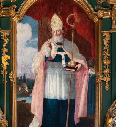 Zdjęcie nr 7: Obraz w kształcie stojącego prostokąta zamkniętego od góry półkolistym łukiem, nadwieszonym, w profilowanej, złoconej ramie ozdobionej motywem muszli w połowie długości dłuższych boków. Został umieszczony w polu środkowym ołtarza bocznego prawego. Postać św. Mikołaja ukazana w pozycji stojącej, frontalnie, we wnętrzu na tle upiętej ciemnoczerwonej draperii. Głowa świętego przechylona nieznacznie w prawo. Twarz owalna, okolona długą, siwą brodą. Oczy duże, głęboko osadzone, wzrok skierowany na wprost. Nos wydatny, prosty, usta zaczerwienione. Na głowie złota infuła, ozdobiona kwadratowym zielonym kamieniem szlachetnym. Wokół głowy nimb. Święty unosi prawą rękę w geście błogosławieństwa, w lewej ręce, o którą oparty jest pastorał, trzyma księgę, z leżącymi na niej trzema złotymi kulami. Ubrany jest w granatową sutannę i białą komżę, układającą się w drobne płytkie fałdy. Na piersi ma paliusz, a na ramionach kapę w kolorze szarym o różowej podszewce. Z lewej strony obrazu okno, w nim widoczny pejzaż z rzeką. Nad rzeką most, przy nim św. Mikołaj wręczający trzem pannom sakiewki z posagiem. Na brzegu rzeki łódź, w głębi widoczny zarys architektury, drzewa i zarysy wzgórz, ponad którymi na błękitnym niebie kłębią się białe chmury. Po prawej stronie obrazu stolik nakryty ciemnobłękitną tkaniną, na nim taca z kwiatami, różańcem i figurką. Kolorystyka obrazu stonowana z silnym akcentem bieli komży i różu podszewki płaszcza.
