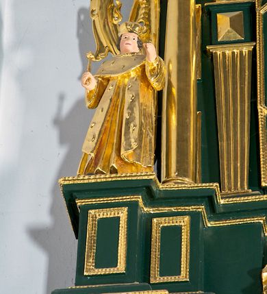 Zdjęcie nr 12: Ołtarz ustawiony na kamiennym podwyższeniu, przyścienny, architektoniczny, jednoosiowy, dwukondygnacyjny ze zwieńczeniem. Podstawa ołtarza skrzyniowa, na niej kamienna mensa z centralnie umieszczonym portatylem. Antepedium późne (secesyjne), datowane na odwrocie „1914”, ozdobione figurą anioła trzymającego wstęgę z napisem „AVE MARIA” i rzeźbionym ornamentem ze złoconych liści winogron i srebrzonych lilii. Retabulum jest flankowane dwiema parami ustawionych uskokowo i osadzonych na wysokich cokołach kolumn kompozytowych, ozdobionych główkami aniołków ujętych dekoracją małżowinową. Kolumny dźwigają belkowanie z wydatnym, przełamującym się gzymsem ozdobionym ornamentem małżowinowym. Nad belkowaniem trójkątny przyczółek z rzeźbioną figurą Boga Ojca w polu tympanonu i figurami aniołów na jego bokach. Druga kondygnacja ołtarza jest flankowana pojedynczymi kolumienkami i kanelowanymi pilasterkami korynckimi, ustawionymi na wysokich cokołach. Boki ozdobione uszami w kształcie małżowiny. Na zewnątrz kolumn, na osiach kolumn zewnętrznych niższej kondygnacji, ustawione na impostach figury: św. Kazimierza po lewej stronie, św. Stanisława po prawej. Kolumny podpierają belkowanie z przełamującym się gzymsem ozdobionym ornamentem małżowinowym, ponad którym zwieńczenie w formie przyczółka odcinkowego przerwanego. Łuk przyczółka profilowany z uskokami, dekorowany ornamentem małżowinowym. Pośrodku zwieńczenia, w przerwanym przyczółku rzeźba św. Michała Archanioła, ustawiona na wysokim cokole z dekoracją w formie bukietu granatów otoczonych liśćmi akantu. Po bokach, na osiach kolumn rzeźbione figury: św. Barbary po lewej stronie i św. Jana Chrzciciela po stronie prawej. Pomiędzy impostami kolumn, w predelli profilowana płycina w kształcie leżącego prostokąta z wyciętymi uskokowo górnymi narożnikami. W niej obraz olejny na płótnie (przyklejony do struktury) ze sceną Nawiedzenia św. Elżbiety. W polu środkowym pierwszej kondygnacji obraz z przedstawieniem Najświętszego Serca Pana Jezusa w profilowanej ramie w kształcie stojącego prostokąta, ozdobionej ornamentem małżowinowym. W drugiej kondygnacji  pole środkowe w kształcie prostokąta leżącego (zbliżonego do kwadratu), obwiedzione frezowaną ramką, z wpisaną w nią ramą o kształcie oktagonalnym, profilowaną i ozdobioną ornamentem małżowinowym, z obrazem przedstawiającym św. Antoniego. Strukturę retabulum, a także prostokątne płyciny zdobiące cokoły i tło kolumn, podkreślają frezowane ramki. Kolumny, pilastry, kapitele, ornamenty, obramienia płycin i belkowania, frezowane ramki złocone. Ramy obrazów złocone i polichromowane. Rzeźby złocone, srebrzone i polichromowane. 