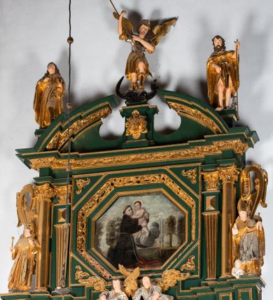 Zdjęcie nr 5: Ołtarz ustawiony na kamiennym podwyższeniu, przyścienny, architektoniczny, jednoosiowy, dwukondygnacyjny ze zwieńczeniem. Podstawa ołtarza skrzyniowa, na niej kamienna mensa z centralnie umieszczonym portatylem. Antepedium późne (secesyjne), datowane na odwrocie „1914”, ozdobione figurą anioła trzymającego wstęgę z napisem „AVE MARIA” i rzeźbionym ornamentem ze złoconych liści winogron i srebrzonych lilii. Retabulum jest flankowane dwiema parami ustawionych uskokowo i osadzonych na wysokich cokołach kolumn kompozytowych, ozdobionych główkami aniołków ujętych dekoracją małżowinową. Kolumny dźwigają belkowanie z wydatnym, przełamującym się gzymsem ozdobionym ornamentem małżowinowym. Nad belkowaniem trójkątny przyczółek z rzeźbioną figurą Boga Ojca w polu tympanonu i figurami aniołów na jego bokach. Druga kondygnacja ołtarza jest flankowana pojedynczymi kolumienkami i kanelowanymi pilasterkami korynckimi, ustawionymi na wysokich cokołach. Boki ozdobione uszami w kształcie małżowiny. Na zewnątrz kolumn, na osiach kolumn zewnętrznych niższej kondygnacji, ustawione na impostach figury: św. Kazimierza po lewej stronie, św. Stanisława po prawej. Kolumny podpierają belkowanie z przełamującym się gzymsem ozdobionym ornamentem małżowinowym, ponad którym zwieńczenie w formie przyczółka odcinkowego przerwanego. Łuk przyczółka profilowany z uskokami, dekorowany ornamentem małżowinowym. Pośrodku zwieńczenia, w przerwanym przyczółku rzeźba św. Michała Archanioła, ustawiona na wysokim cokole z dekoracją w formie bukietu granatów otoczonych liśćmi akantu. Po bokach, na osiach kolumn rzeźbione figury: św. Barbary po lewej stronie i św. Jana Chrzciciela po stronie prawej. Pomiędzy impostami kolumn, w predelli profilowana płycina w kształcie leżącego prostokąta z wyciętymi uskokowo górnymi narożnikami. W niej obraz olejny na płótnie (przyklejony do struktury) ze sceną Nawiedzenia św. Elżbiety. W polu środkowym pierwszej kondygnacji obraz z przedstawieniem Najświętszego Serca Pana Jezusa w profilowanej ramie w kształcie stojącego prostokąta, ozdobionej ornamentem małżowinowym. W drugiej kondygnacji  pole środkowe w kształcie prostokąta leżącego (zbliżonego do kwadratu), obwiedzione frezowaną ramką, z wpisaną w nią ramą o kształcie oktagonalnym, profilowaną i ozdobioną ornamentem małżowinowym, z obrazem przedstawiającym św. Antoniego. Strukturę retabulum, a także prostokątne płyciny zdobiące cokoły i tło kolumn, podkreślają frezowane ramki. Kolumny, pilastry, kapitele, ornamenty, obramienia płycin i belkowania, frezowane ramki złocone. Ramy obrazów złocone i polichromowane. Rzeźby złocone, srebrzone i polichromowane. 