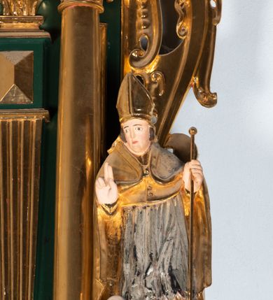 Zdjęcie nr 13: Ołtarz ustawiony na kamiennym podwyższeniu, przyścienny, architektoniczny, jednoosiowy, dwukondygnacyjny ze zwieńczeniem. Podstawa ołtarza skrzyniowa, na niej kamienna mensa z centralnie umieszczonym portatylem. Antepedium późne (secesyjne), datowane na odwrocie „1914”, ozdobione figurą anioła trzymającego wstęgę z napisem „AVE MARIA” i rzeźbionym ornamentem ze złoconych liści winogron i srebrzonych lilii. Retabulum jest flankowane dwiema parami ustawionych uskokowo i osadzonych na wysokich cokołach kolumn kompozytowych, ozdobionych główkami aniołków ujętych dekoracją małżowinową. Kolumny dźwigają belkowanie z wydatnym, przełamującym się gzymsem ozdobionym ornamentem małżowinowym. Nad belkowaniem trójkątny przyczółek z rzeźbioną figurą Boga Ojca w polu tympanonu i figurami aniołów na jego bokach. Druga kondygnacja ołtarza jest flankowana pojedynczymi kolumienkami i kanelowanymi pilasterkami korynckimi, ustawionymi na wysokich cokołach. Boki ozdobione uszami w kształcie małżowiny. Na zewnątrz kolumn, na osiach kolumn zewnętrznych niższej kondygnacji, ustawione na impostach figury: św. Kazimierza po lewej stronie, św. Stanisława po prawej. Kolumny podpierają belkowanie z przełamującym się gzymsem ozdobionym ornamentem małżowinowym, ponad którym zwieńczenie w formie przyczółka odcinkowego przerwanego. Łuk przyczółka profilowany z uskokami, dekorowany ornamentem małżowinowym. Pośrodku zwieńczenia, w przerwanym przyczółku rzeźba św. Michała Archanioła, ustawiona na wysokim cokole z dekoracją w formie bukietu granatów otoczonych liśćmi akantu. Po bokach, na osiach kolumn rzeźbione figury: św. Barbary po lewej stronie i św. Jana Chrzciciela po stronie prawej. Pomiędzy impostami kolumn, w predelli profilowana płycina w kształcie leżącego prostokąta z wyciętymi uskokowo górnymi narożnikami. W niej obraz olejny na płótnie (przyklejony do struktury) ze sceną Nawiedzenia św. Elżbiety. W polu środkowym pierwszej kondygnacji obraz z przedstawieniem Najświętszego Serca Pana Jezusa w profilowanej ramie w kształcie stojącego prostokąta, ozdobionej ornamentem małżowinowym. W drugiej kondygnacji  pole środkowe w kształcie prostokąta leżącego (zbliżonego do kwadratu), obwiedzione frezowaną ramką, z wpisaną w nią ramą o kształcie oktagonalnym, profilowaną i ozdobioną ornamentem małżowinowym, z obrazem przedstawiającym św. Antoniego. Strukturę retabulum, a także prostokątne płyciny zdobiące cokoły i tło kolumn, podkreślają frezowane ramki. Kolumny, pilastry, kapitele, ornamenty, obramienia płycin i belkowania, frezowane ramki złocone. Ramy obrazów złocone i polichromowane. Rzeźby złocone, srebrzone i polichromowane. 