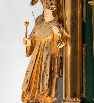 Zdjęcie nr 15: Ołtarz ustawiony na kamiennym podwyższeniu, przyścienny, architektoniczny, jednoosiowy, dwukondygnacyjny ze zwieńczeniem. Podstawa ołtarza skrzyniowa, na niej kamienna mensa z centralnie umieszczonym portatylem. Antepedium późne (secesyjne), datowane na odwrocie „1914”, ozdobione figurą anioła trzymającego wstęgę z napisem „AVE MARIA” i rzeźbionym ornamentem ze złoconych liści winogron i srebrzonych lilii. Retabulum jest flankowane dwiema parami ustawionych uskokowo i osadzonych na wysokich cokołach kolumn kompozytowych, ozdobionych główkami aniołków ujętych dekoracją małżowinową. Kolumny dźwigają belkowanie z wydatnym, przełamującym się gzymsem ozdobionym ornamentem małżowinowym. Nad belkowaniem trójkątny przyczółek z rzeźbioną figurą Boga Ojca w polu tympanonu i figurami aniołów na jego bokach. Druga kondygnacja ołtarza jest flankowana pojedynczymi kolumienkami i kanelowanymi pilasterkami korynckimi, ustawionymi na wysokich cokołach. Boki ozdobione uszami w kształcie małżowiny. Na zewnątrz kolumn, na osiach kolumn zewnętrznych niższej kondygnacji, ustawione na impostach figury: św. Kazimierza po lewej stronie, św. Stanisława po prawej. Kolumny podpierają belkowanie z przełamującym się gzymsem ozdobionym ornamentem małżowinowym, ponad którym zwieńczenie w formie przyczółka odcinkowego przerwanego. Łuk przyczółka profilowany z uskokami, dekorowany ornamentem małżowinowym. Pośrodku zwieńczenia, w przerwanym przyczółku rzeźba św. Michała Archanioła, ustawiona na wysokim cokole z dekoracją w formie bukietu granatów otoczonych liśćmi akantu. Po bokach, na osiach kolumn rzeźbione figury: św. Barbary po lewej stronie i św. Jana Chrzciciela po stronie prawej. Pomiędzy impostami kolumn, w predelli profilowana płycina w kształcie leżącego prostokąta z wyciętymi uskokowo górnymi narożnikami. W niej obraz olejny na płótnie (przyklejony do struktury) ze sceną Nawiedzenia św. Elżbiety. W polu środkowym pierwszej kondygnacji obraz z przedstawieniem Najświętszego Serca Pana Jezusa w profilowanej ramie w kształcie stojącego prostokąta, ozdobionej ornamentem małżowinowym. W drugiej kondygnacji  pole środkowe w kształcie prostokąta leżącego (zbliżonego do kwadratu), obwiedzione frezowaną ramką, z wpisaną w nią ramą o kształcie oktagonalnym, profilowaną i ozdobioną ornamentem małżowinowym, z obrazem przedstawiającym św. Antoniego. Strukturę retabulum, a także prostokątne płyciny zdobiące cokoły i tło kolumn, podkreślają frezowane ramki. Kolumny, pilastry, kapitele, ornamenty, obramienia płycin i belkowania, frezowane ramki złocone. Ramy obrazów złocone i polichromowane. Rzeźby złocone, srebrzone i polichromowane. 