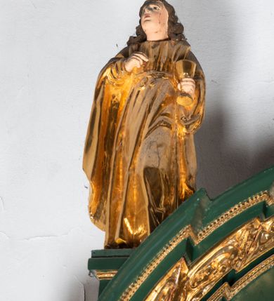 Zdjęcie nr 19: Ołtarz ustawiony na kamiennym podwyższeniu, przyścienny, architektoniczny, jednoosiowy, dwukondygnacyjny ze zwieńczeniem. Podstawa ołtarza skrzyniowa, na niej kamienna mensa z centralnie umieszczonym portatylem. Antepedium późne (secesyjne), datowane na odwrocie „1914”, ozdobione figurą anioła trzymającego wstęgę z napisem „AVE MARIA” i rzeźbionym ornamentem ze złoconych liści winogron i srebrzonych lilii. Retabulum jest flankowane dwiema parami ustawionych uskokowo i osadzonych na wysokich cokołach kolumn kompozytowych, ozdobionych główkami aniołków ujętych dekoracją małżowinową. Kolumny dźwigają belkowanie z wydatnym, przełamującym się gzymsem ozdobionym ornamentem małżowinowym. Nad belkowaniem trójkątny przyczółek z rzeźbioną figurą Boga Ojca w polu tympanonu i figurami aniołów na jego bokach. Druga kondygnacja ołtarza jest flankowana pojedynczymi kolumienkami i kanelowanymi pilasterkami korynckimi, ustawionymi na wysokich cokołach. Boki ozdobione uszami w kształcie małżowiny. Na zewnątrz kolumn, na osiach kolumn zewnętrznych niższej kondygnacji, ustawione na impostach figury: św. Kazimierza po lewej stronie, św. Stanisława po prawej. Kolumny podpierają belkowanie z przełamującym się gzymsem ozdobionym ornamentem małżowinowym, ponad którym zwieńczenie w formie przyczółka odcinkowego przerwanego. Łuk przyczółka profilowany z uskokami, dekorowany ornamentem małżowinowym. Pośrodku zwieńczenia, w przerwanym przyczółku rzeźba św. Michała Archanioła, ustawiona na wysokim cokole z dekoracją w formie bukietu granatów otoczonych liśćmi akantu. Po bokach, na osiach kolumn rzeźbione figury: św. Barbary po lewej stronie i św. Jana Chrzciciela po stronie prawej. Pomiędzy impostami kolumn, w predelli profilowana płycina w kształcie leżącego prostokąta z wyciętymi uskokowo górnymi narożnikami. W niej obraz olejny na płótnie (przyklejony do struktury) ze sceną Nawiedzenia św. Elżbiety. W polu środkowym pierwszej kondygnacji obraz z przedstawieniem Najświętszego Serca Pana Jezusa w profilowanej ramie w kształcie stojącego prostokąta, ozdobionej ornamentem małżowinowym. W drugiej kondygnacji  pole środkowe w kształcie prostokąta leżącego (zbliżonego do kwadratu), obwiedzione frezowaną ramką, z wpisaną w nią ramą o kształcie oktagonalnym, profilowaną i ozdobioną ornamentem małżowinowym, z obrazem przedstawiającym św. Antoniego. Strukturę retabulum, a także prostokątne płyciny zdobiące cokoły i tło kolumn, podkreślają frezowane ramki. Kolumny, pilastry, kapitele, ornamenty, obramienia płycin i belkowania, frezowane ramki złocone. Ramy obrazów złocone i polichromowane. Rzeźby złocone, srebrzone i polichromowane. 