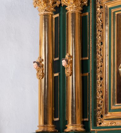 Zdjęcie nr 63: Ołtarz ustawiony na kamiennym podwyższeniu, przyścienny, architektoniczny, jednoosiowy, dwukondygnacyjny ze zwieńczeniem. Podstawa ołtarza skrzyniowa, na niej kamienna mensa z centralnie umieszczonym portatylem. Antepedium późne (secesyjne), datowane na odwrocie „1914”, ozdobione figurą anioła trzymającego wstęgę z napisem „AVE MARIA” i rzeźbionym ornamentem ze złoconych liści winogron i srebrzonych lilii. Retabulum jest flankowane dwiema parami ustawionych uskokowo i osadzonych na wysokich cokołach kolumn kompozytowych, ozdobionych główkami aniołków ujętych dekoracją małżowinową. Kolumny dźwigają belkowanie z wydatnym, przełamującym się gzymsem ozdobionym ornamentem małżowinowym. Nad belkowaniem trójkątny przyczółek z rzeźbioną figurą Boga Ojca w polu tympanonu i figurami aniołów na jego bokach. Druga kondygnacja ołtarza jest flankowana pojedynczymi kolumienkami i kanelowanymi pilasterkami korynckimi, ustawionymi na wysokich cokołach. Boki ozdobione uszami w kształcie małżowiny. Na zewnątrz kolumn, na osiach kolumn zewnętrznych niższej kondygnacji, ustawione na impostach figury: św. Kazimierza po lewej stronie, św. Stanisława po prawej. Kolumny podpierają belkowanie z przełamującym się gzymsem ozdobionym ornamentem małżowinowym, ponad którym zwieńczenie w formie przyczółka odcinkowego przerwanego. Łuk przyczółka profilowany z uskokami, dekorowany ornamentem małżowinowym. Pośrodku zwieńczenia, w przerwanym przyczółku rzeźba św. Michała Archanioła, ustawiona na wysokim cokole z dekoracją w formie bukietu granatów otoczonych liśćmi akantu. Po bokach, na osiach kolumn rzeźbione figury: św. Barbary po lewej stronie i św. Jana Chrzciciela po stronie prawej. Pomiędzy impostami kolumn, w predelli profilowana płycina w kształcie leżącego prostokąta z wyciętymi uskokowo górnymi narożnikami. W niej obraz olejny na płótnie (przyklejony do struktury) ze sceną Nawiedzenia św. Elżbiety. W polu środkowym pierwszej kondygnacji obraz z przedstawieniem Najświętszego Serca Pana Jezusa w profilowanej ramie w kształcie stojącego prostokąta, ozdobionej ornamentem małżowinowym. W drugiej kondygnacji  pole środkowe w kształcie prostokąta leżącego (zbliżonego do kwadratu), obwiedzione frezowaną ramką, z wpisaną w nią ramą o kształcie oktagonalnym, profilowaną i ozdobioną ornamentem małżowinowym, z obrazem przedstawiającym św. Antoniego. Strukturę retabulum, a także prostokątne płyciny zdobiące cokoły i tło kolumn, podkreślają frezowane ramki. Kolumny, pilastry, kapitele, ornamenty, obramienia płycin i belkowania, frezowane ramki złocone. Ramy obrazów złocone i polichromowane. Rzeźby złocone, srebrzone i polichromowane. 