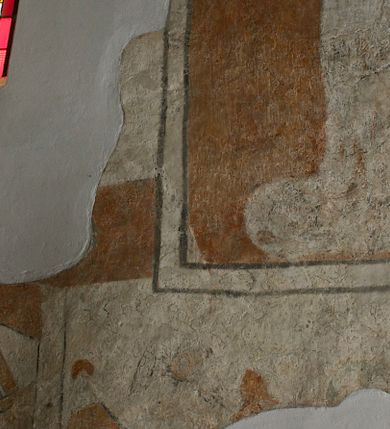 Zdjęcie nr 1: Polichromia na ścianie wschodniej (przesłonięta ołtarzem głównym, trudno dostępna) i na ścianie południowej prezbiterium to malowidło o kompozycji obejmującej „luźne” obrazy zachowane jedynie szczątkowo. Na ścianie wschodniej polichromia obejmuje uproszczoną wić arabeskową, zdobiącą glify zamurowanego ostrołukowego okna, a także fragment nadnaturalnej wielkości postaci, którą identyfikowano ze św. Krzysztofem. W tej części malowideł zachowała się również data „1476” wymalowana sangwiną. Na ścianie południowej widnieje zarys niezidentyfikowanej świętej w kwaterze o kształcie stojącego prostokąta, obwiedzionej ramą, której kontur zaznaczony został szaroczarną linią, a także fragmenty ciągłego motywu z aniołami podtrzymującymi draperię, odcinającego dolną strefę niezachowanej kompozycji. Zachowane fragmenty polichromii są w kolorach ugru, perłowej szarości, kontury zaś podkreślone czernią.