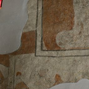 Zdjęcie nr 1: Polichromia na ścianie wschodniej (przesłonięta ołtarzem głównym, trudno dostępna) i na ścianie południowej prezbiterium to malowidło o kompozycji obejmującej „luźne” obrazy zachowane jedynie szczątkowo. Na ścianie wschodniej polichromia obejmuje uproszczoną wić arabeskową, zdobiącą glify zamurowanego ostrołukowego okna, a także fragment nadnaturalnej wielkości postaci, którą identyfikowano ze św. Krzysztofem. W tej części malowideł zachowała się również data „1476” wymalowana sangwiną. Na ścianie południowej widnieje zarys niezidentyfikowanej świętej w kwaterze o kształcie stojącego prostokąta, obwiedzionej ramą, której kontur zaznaczony został szaroczarną linią, a także fragmenty ciągłego motywu z aniołami podtrzymującymi draperię, odcinającego dolną strefę niezachowanej kompozycji. Zachowane fragmenty polichromii są w kolorach ugru, perłowej szarości, kontury zaś podkreślone czernią.
