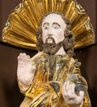 Zdjęcie nr 20: Ambona drewniana, przyścienna, wisząca, dostawiona do północnej ściany nawy ze schodkami biegnącymi wzdłuż ściany. Kosz ambony jest sześcioboczny, z niewielkim parapetem. Jego boki zostały podzielone na pola stojącymi na wysokich cokołach pięcioma kolumienkami o korynckich kapitelach, dźwigających profilowane belkowanie. W polach prostokątne płyciny z konchowymi wnękami ozdobionymi muszlami z figurami ewangelistów. 
We wnękach rzeźby z przedstawieniami ewangelistów i Chrystusa. Figury drewniane pełnoplastyczne, wydrążone od tyłu, polichromowane, złocone i srebrzone, ustawione na niewielkich prostokątnych podstawach, od lewej: św. Łukasz wsparty prawą nogą na głowie byka, św. Marek wsparty prawą nogą na głowie lwa, św. Jan z orłem przy prawej nodze, Chrystus Salvator Mundi, św. Mateusz z aniołem przy prawej nodze. Ewangeliści trzymają w prawych dłoniach otwarte księgi, z wyjątkiem św. Mateusza, trzymającego kodeks w lewej ręce. Dłonie ewangelistów nieproporcjonalnie duże. Szaty bogato pofałdowane, głęboko cięte. 
Podstawa kosza bogato profilowana, ozdobiona podwieszoną dekoracyjną szyszką. Schodki ograniczone parapetem z trzema romboidalnymi płycinami w złoconych profilowanych obramieniach. Na filarze przy wejściu na schodki złocona kula z szyszką. Zaplecek w kształcie stojącego prostokąta, w górnej części ujęty zwężającymi się ku dołowi pilastrami wypełnionymi cekinami, zwieńczonymi rombowymi wypustkami i korynckimi kapitelami, które podtrzymują przełamujące się nad nimi belkowanie. Pośrodku zaplecka w prostokątnym obramieniu zamkniętym nadwieszonym łukiem półkolistym płaskorzeźbione popiersie Boga Ojca wyłaniającego się z obłoków. Prawa ręka Boga wzniesiona w geście błogosławieństwa, lewa oparta na globie ziemskim zwieńczonym krzyżem. Tłem dla postaci Boga Ojca jest rozwiana poła płaszcza układająca się niemal półkoliście. Baldachim ośmioboczny. W profilowanym podniebiu, ozdobionym pasem ornamentu małżowinowo-chrząstkowego i profilowanymi wisiorami, gołębica Ducha Świętego na tle glorii utworzonej z prostych promieni o równej długości. Baldachim ozdobiony zamkniętą koroną, którą tworzy pięć esownic pokrytych pasami ornamentu małżowinowo-chrząstkowego. W zwieńczeniu pełnoplastyczna rzeźba przedstawiająca św. Jana Chrzciciela. Figura drewniana, wydrążona z tyłu, polichromowana, złocona i srebrzona, ustawiona na niewielkiej wielobocznej profilowanej podstawie. Święty w prawej ręce trzyma wysoki krzyż, w lewej księgę, na której spoczywa Baranek Boży. Struktura ambony ciemnobrązowa. Kolumny, kapitele, pilastry w zaplecku korona baldachimu, profilowania i ornamenty złocone, z wyjątkiem srebrzonej ramy w zaplecku i gołębicy Ducha Świętego.