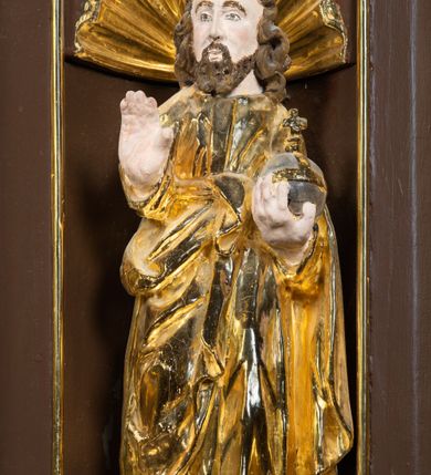 Zdjęcie nr 21: Ambona drewniana, przyścienna, wisząca, dostawiona do północnej ściany nawy ze schodkami biegnącymi wzdłuż ściany. Kosz ambony jest sześcioboczny, z niewielkim parapetem. Jego boki zostały podzielone na pola stojącymi na wysokich cokołach pięcioma kolumienkami o korynckich kapitelach, dźwigających profilowane belkowanie. W polach prostokątne płyciny z konchowymi wnękami ozdobionymi muszlami z figurami ewangelistów. 
We wnękach rzeźby z przedstawieniami ewangelistów i Chrystusa. Figury drewniane pełnoplastyczne, wydrążone od tyłu, polichromowane, złocone i srebrzone, ustawione na niewielkich prostokątnych podstawach, od lewej: św. Łukasz wsparty prawą nogą na głowie byka, św. Marek wsparty prawą nogą na głowie lwa, św. Jan z orłem przy prawej nodze, Chrystus Salvator Mundi, św. Mateusz z aniołem przy prawej nodze. Ewangeliści trzymają w prawych dłoniach otwarte księgi, z wyjątkiem św. Mateusza, trzymającego kodeks w lewej ręce. Dłonie ewangelistów nieproporcjonalnie duże. Szaty bogato pofałdowane, głęboko cięte. 
Podstawa kosza bogato profilowana, ozdobiona podwieszoną dekoracyjną szyszką. Schodki ograniczone parapetem z trzema romboidalnymi płycinami w złoconych profilowanych obramieniach. Na filarze przy wejściu na schodki złocona kula z szyszką. Zaplecek w kształcie stojącego prostokąta, w górnej części ujęty zwężającymi się ku dołowi pilastrami wypełnionymi cekinami, zwieńczonymi rombowymi wypustkami i korynckimi kapitelami, które podtrzymują przełamujące się nad nimi belkowanie. Pośrodku zaplecka w prostokątnym obramieniu zamkniętym nadwieszonym łukiem półkolistym płaskorzeźbione popiersie Boga Ojca wyłaniającego się z obłoków. Prawa ręka Boga wzniesiona w geście błogosławieństwa, lewa oparta na globie ziemskim zwieńczonym krzyżem. Tłem dla postaci Boga Ojca jest rozwiana poła płaszcza układająca się niemal półkoliście. Baldachim ośmioboczny. W profilowanym podniebiu, ozdobionym pasem ornamentu małżowinowo-chrząstkowego i profilowanymi wisiorami, gołębica Ducha Świętego na tle glorii utworzonej z prostych promieni o równej długości. Baldachim ozdobiony zamkniętą koroną, którą tworzy pięć esownic pokrytych pasami ornamentu małżowinowo-chrząstkowego. W zwieńczeniu pełnoplastyczna rzeźba przedstawiająca św. Jana Chrzciciela. Figura drewniana, wydrążona z tyłu, polichromowana, złocona i srebrzona, ustawiona na niewielkiej wielobocznej profilowanej podstawie. Święty w prawej ręce trzyma wysoki krzyż, w lewej księgę, na której spoczywa Baranek Boży. Struktura ambony ciemnobrązowa. Kolumny, kapitele, pilastry w zaplecku korona baldachimu, profilowania i ornamenty złocone, z wyjątkiem srebrzonej ramy w zaplecku i gołębicy Ducha Świętego.