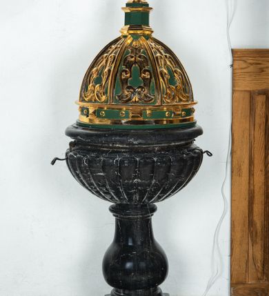 Zdjęcie nr 4: Na okrągłej podstawie, częściowo wmurowanej w ścianę oraz prostopadłościennym cokole niewielka stopa z trzonem w typie balustradowej lalki podtrzymującej półkulistą czarę o powierzchni imitującej puklowanie z wklęską i zaoblonym brzegiem. Na kwadratowej podstawie data: „A(NNO) D(OMINI) 1707”. Pokrywa  w kształcie smukłej półkopuły, ośmiopolowa, z żebrami. W polach między żebrami dekoracja z ornamentu małżowinowego. Latarnia ośmioboczna z profilowanym cokołem i gzymsem. Na latarni jajowata kula z toczonym daszkiem zwieńczonym guzem w kształcie zbliżonym do szyszki. Żebra kopuły, elementy dekoracyjne i ornamenty złocone. Tła i ściany latarni polichromowane, ciemnozielone.