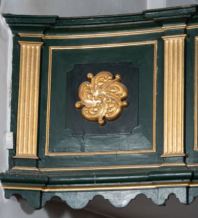 Zdjęcie nr 12: Chór muzyczny na zachodniej ścianie nawy, wsparty na dwóch słupach, ozdobionych od strony nawy dwoma kanelowanymi pilastrami o kapitelach kompozytowych. Jego parapet jest wklęsło-wypukły, z profilowanym cokołem, podzielony na kwatery kanelowanymi i złoconymi pilastrami. W kwaterach wypukłe pola kwadratowe o ćwierkolistych narożach ozdobione rzeźbionymi stylizowanymi rozetami. Parapet zwieńczony niewielkim gzymsem przełamanym na osi pilastrów. Pod listwą cokołu falisty fartuch. Struktura chóru muzycznego ciemnozielona. Pola płycin oliwkowo-ciemnozielone. Pilasty, rozety i profilowania są złocone. 
Znajdujący się na chórze prospekt wsparty na cokole z czterema kroksztynami, trzyosiowy, z osiami wydzielonymi kwadratowymi w podstawie filarkami. Oś środkowa podzielona na wie strefy: dolną z dwiema arkadkami z kostkowanym gzymsem i górną zamkniętą łukiem odcinkowym. Osie boczne zakończone gzymsem z kostkowaniem. W partii cokołowej bogato rzeźbiony motyw małżowinowo-chrząstkowy. 