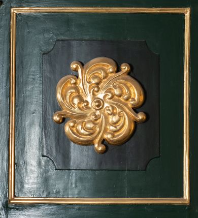 Zdjęcie nr 13: Chór muzyczny na zachodniej ścianie nawy, wsparty na dwóch słupach, ozdobionych od strony nawy dwoma kanelowanymi pilastrami o kapitelach kompozytowych. Jego parapet jest wklęsło-wypukły, z profilowanym cokołem, podzielony na kwatery kanelowanymi i złoconymi pilastrami. W kwaterach wypukłe pola kwadratowe o ćwierkolistych narożach ozdobione rzeźbionymi stylizowanymi rozetami. Parapet zwieńczony niewielkim gzymsem przełamanym na osi pilastrów. Pod listwą cokołu falisty fartuch. Struktura chóru muzycznego ciemnozielona. Pola płycin oliwkowo-ciemnozielone. Pilasty, rozety i profilowania są złocone. 
Znajdujący się na chórze prospekt wsparty na cokole z czterema kroksztynami, trzyosiowy, z osiami wydzielonymi kwadratowymi w podstawie filarkami. Oś środkowa podzielona na wie strefy: dolną z dwiema arkadkami z kostkowanym gzymsem i górną zamkniętą łukiem odcinkowym. Osie boczne zakończone gzymsem z kostkowaniem. W partii cokołowej bogato rzeźbiony motyw małżowinowo-chrząstkowy. 